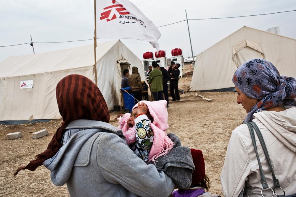 Une réfugiée syrienne porte son enfant à la clinique médicale de MSF dans le camp de Domeez, au nord-ouest du Kurdistan irakien.  Janvier 2013 