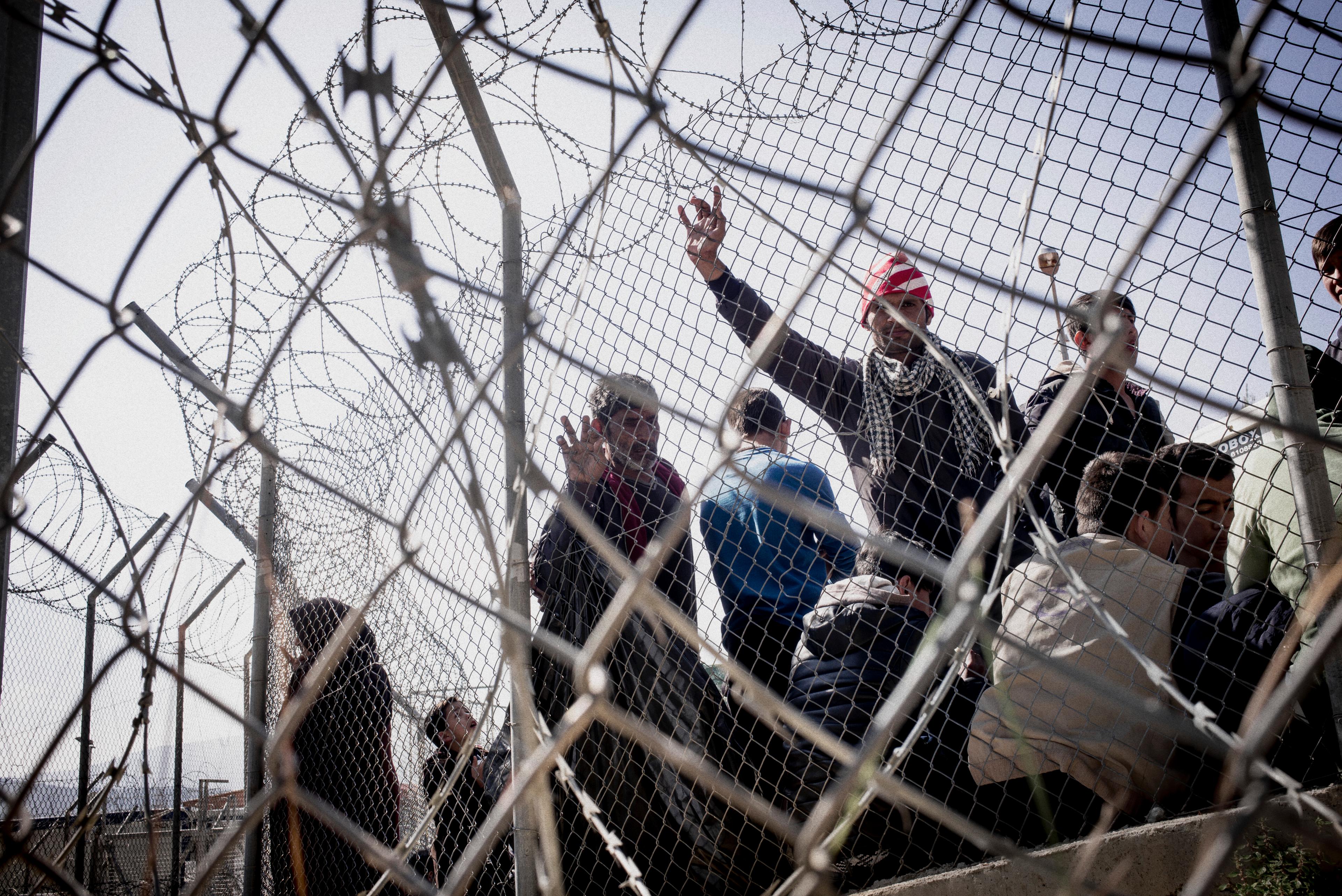 Demandeurs d'asile derrière une clôture en fil de fer barbelé à Vathy.  Samos. mars 2016. 
