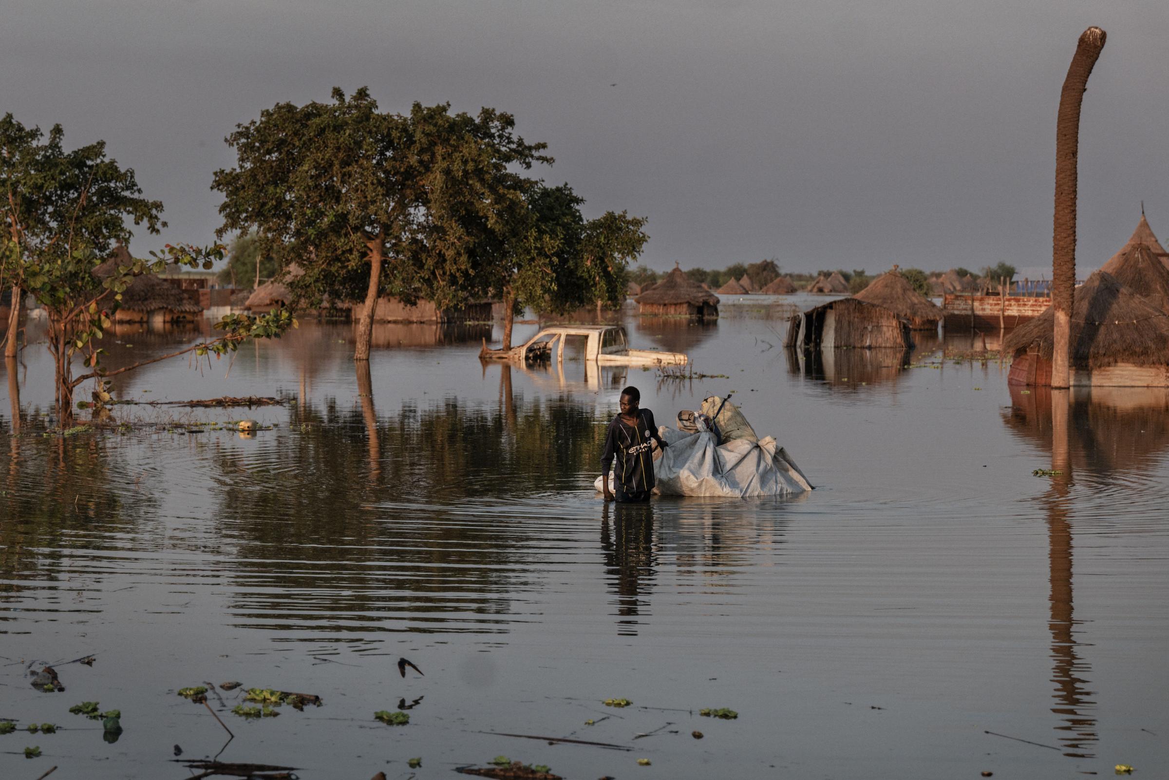 Un homme tire un radeau en bâche à travers les eaux de crue à Rubkona, dans l’État d’Unity.  Dans tout l’État d’Unity, les habitations et les moyens de subsistance des habitants (cultures et bétail), ainsi que les établissements de santé, les écoles et les marchés, sont complètement submergés par les eaux de crue.