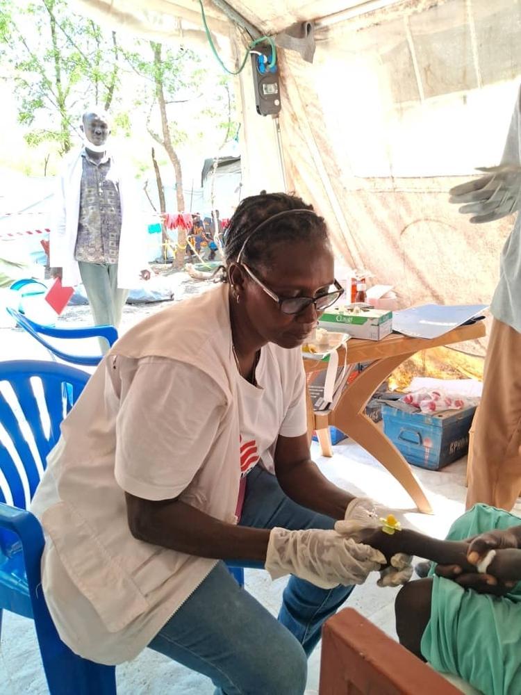Un membre du personnel de MSF pose une perfusion à un patient atteint de choléra. © MSF