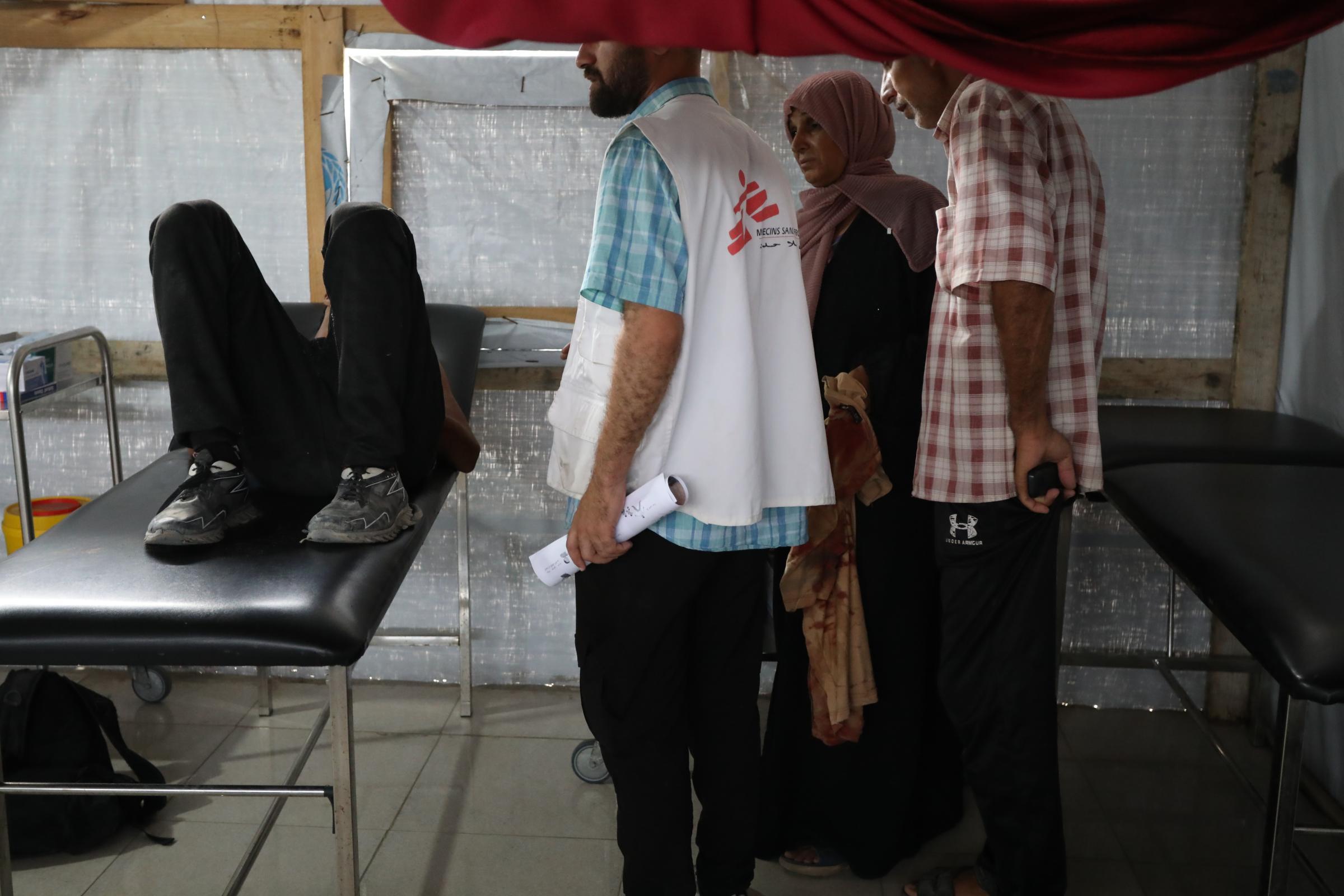 Ashraf, 7 ans, est soigné par le personnel de MSF dans une clinique de soins de base après avoir été gravement blessé sur un site de distribution de l'aide américaine israélienne. Bande de Gaza, juin, 2025. © Nour Alsaqqa/MSF