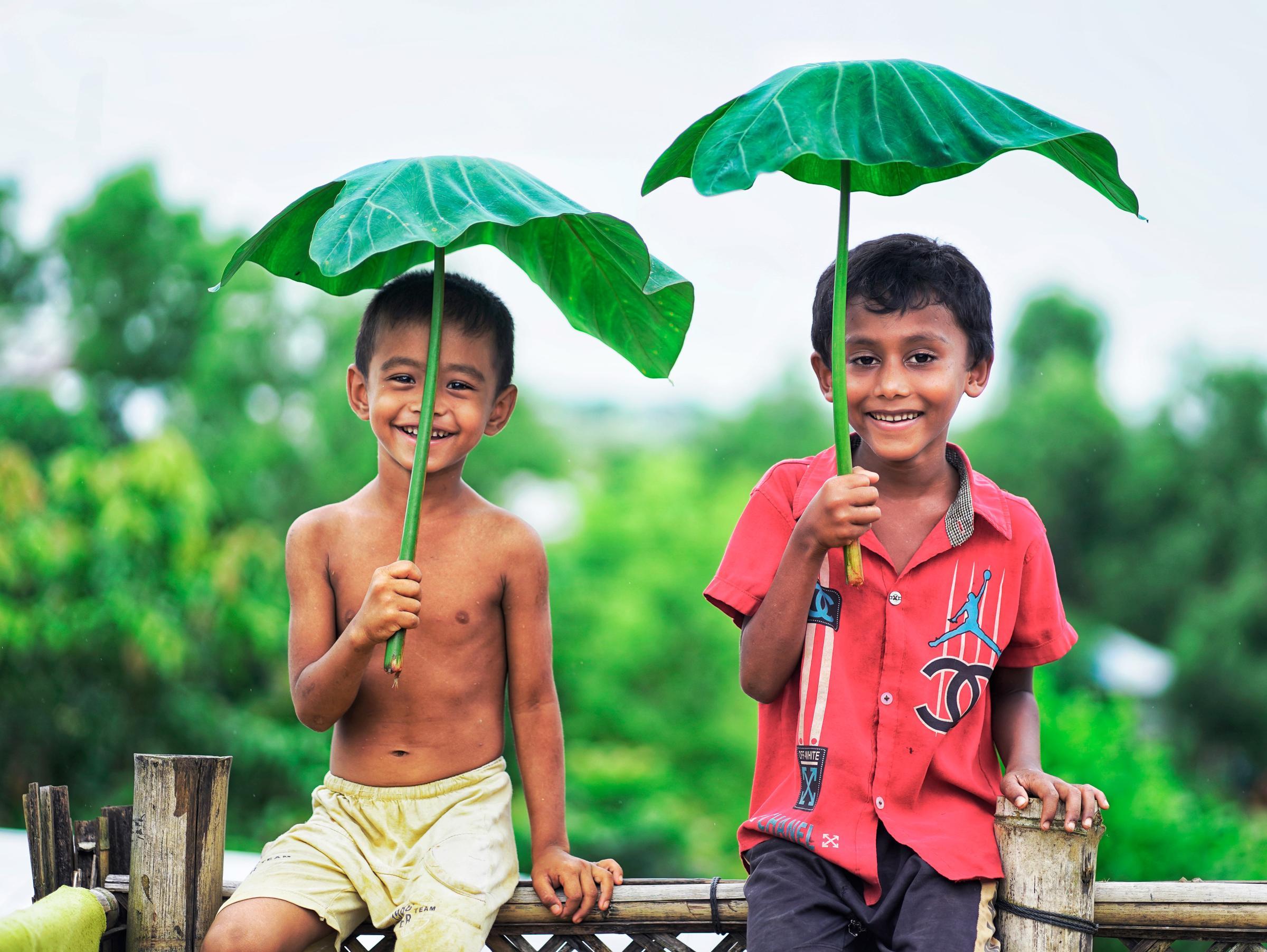 Deux enfants portant des feuilles de Taro en guise de parapluie
