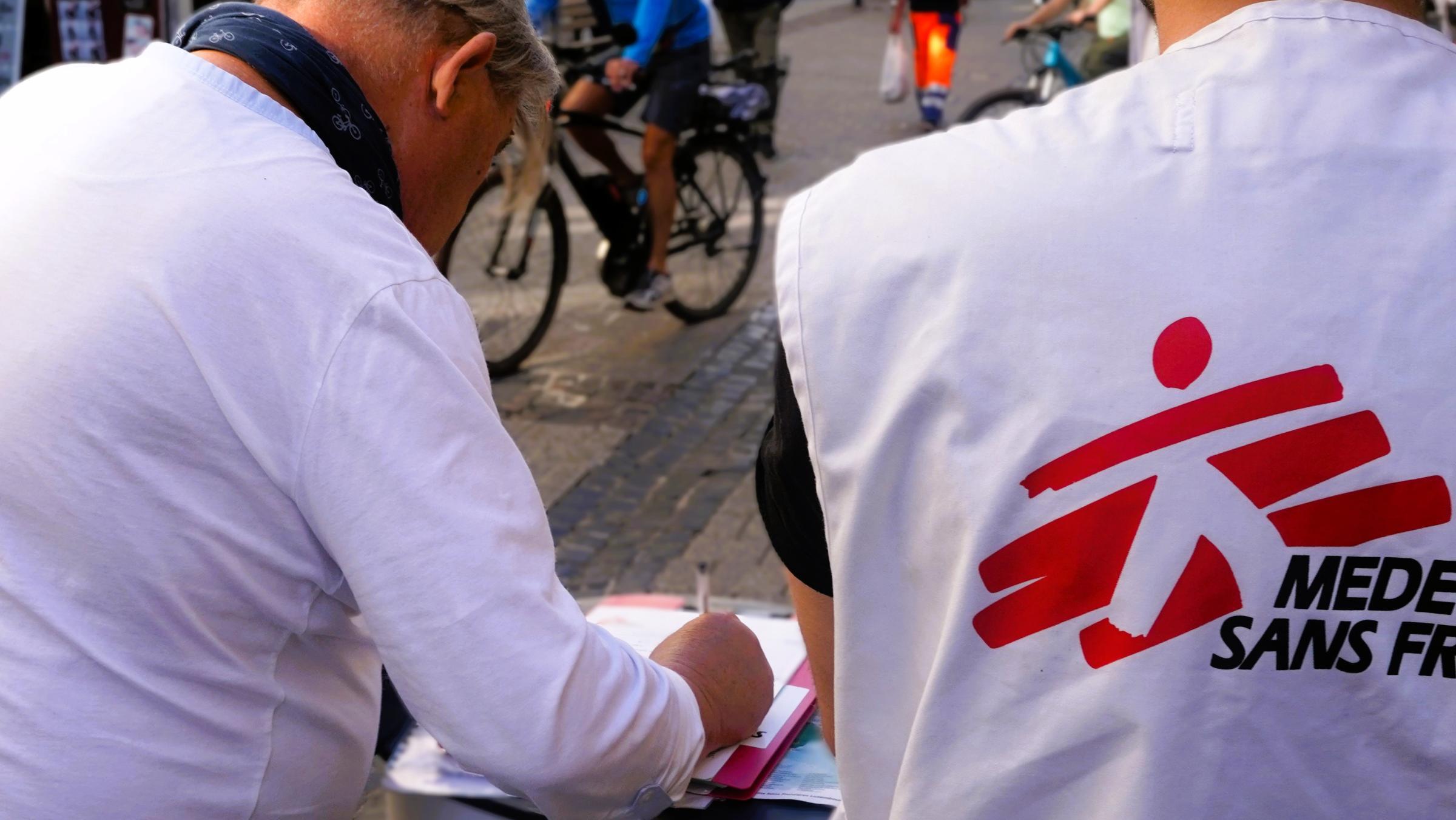 Un passant signe un formulaire pour devenir donateur régulier de MSF, accompagné des équipes de recruteurs en rue. Luxembourg, septembre, 2026 © Crisitna Fernandez/ MSF
