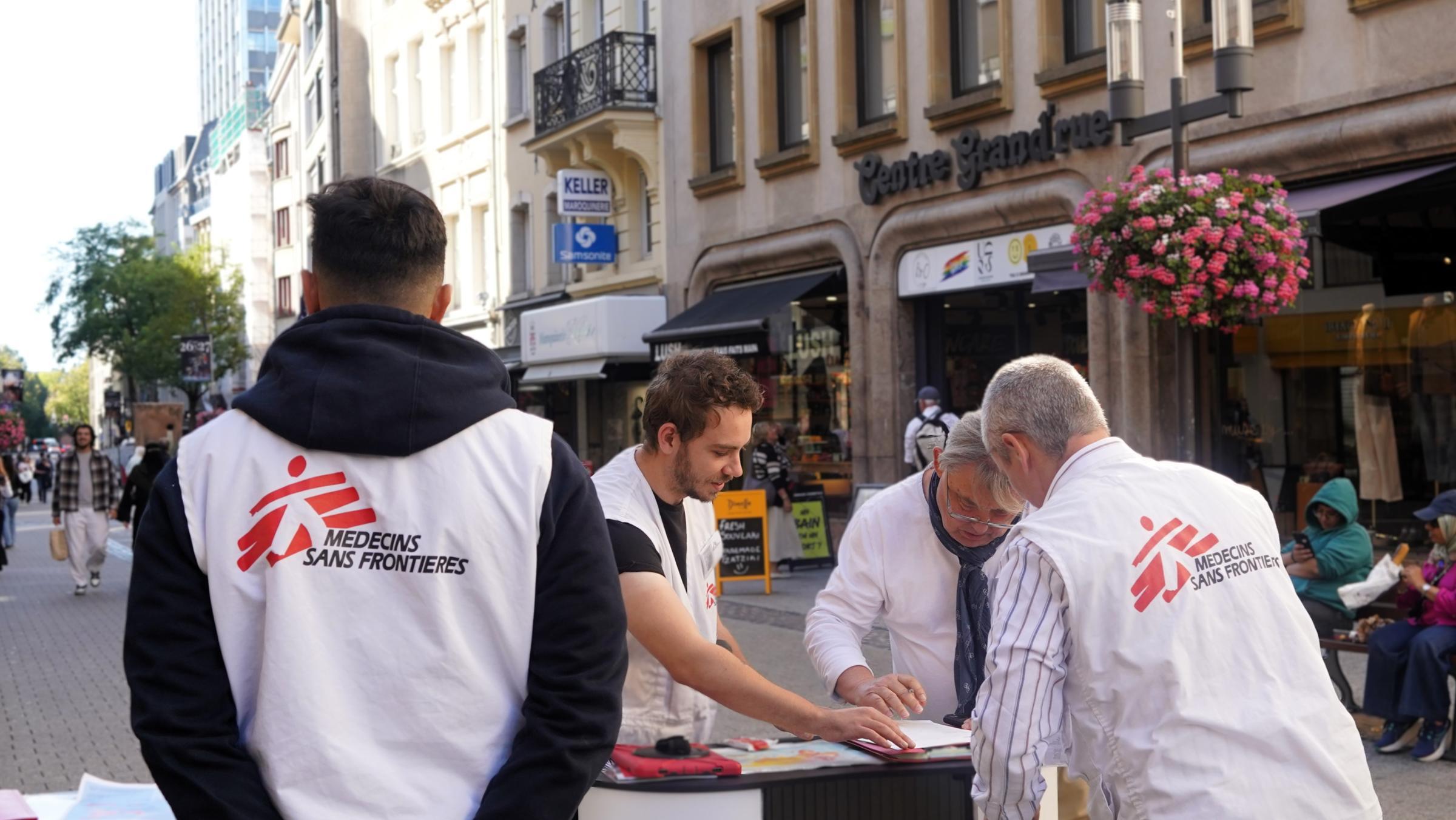 Un passant signe un formulaire pour devenir donateur régulier de MSF, accompagné des équipes de recruteurs en rue. Luxembourg, septembre, 2026 © Crisitna Fernandez/ MSF
