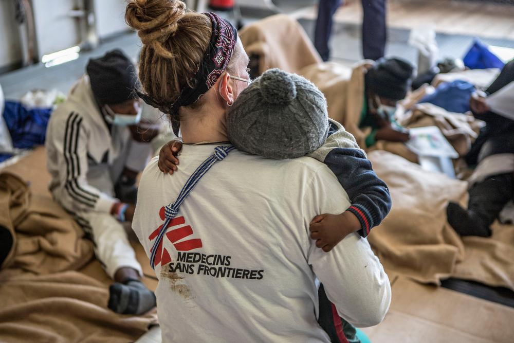 Une employée de MSF tient dans ses bras l'une des plus jeunes survivantes à bord du Geo Barents.  ©Anna Pantelia/MSF 