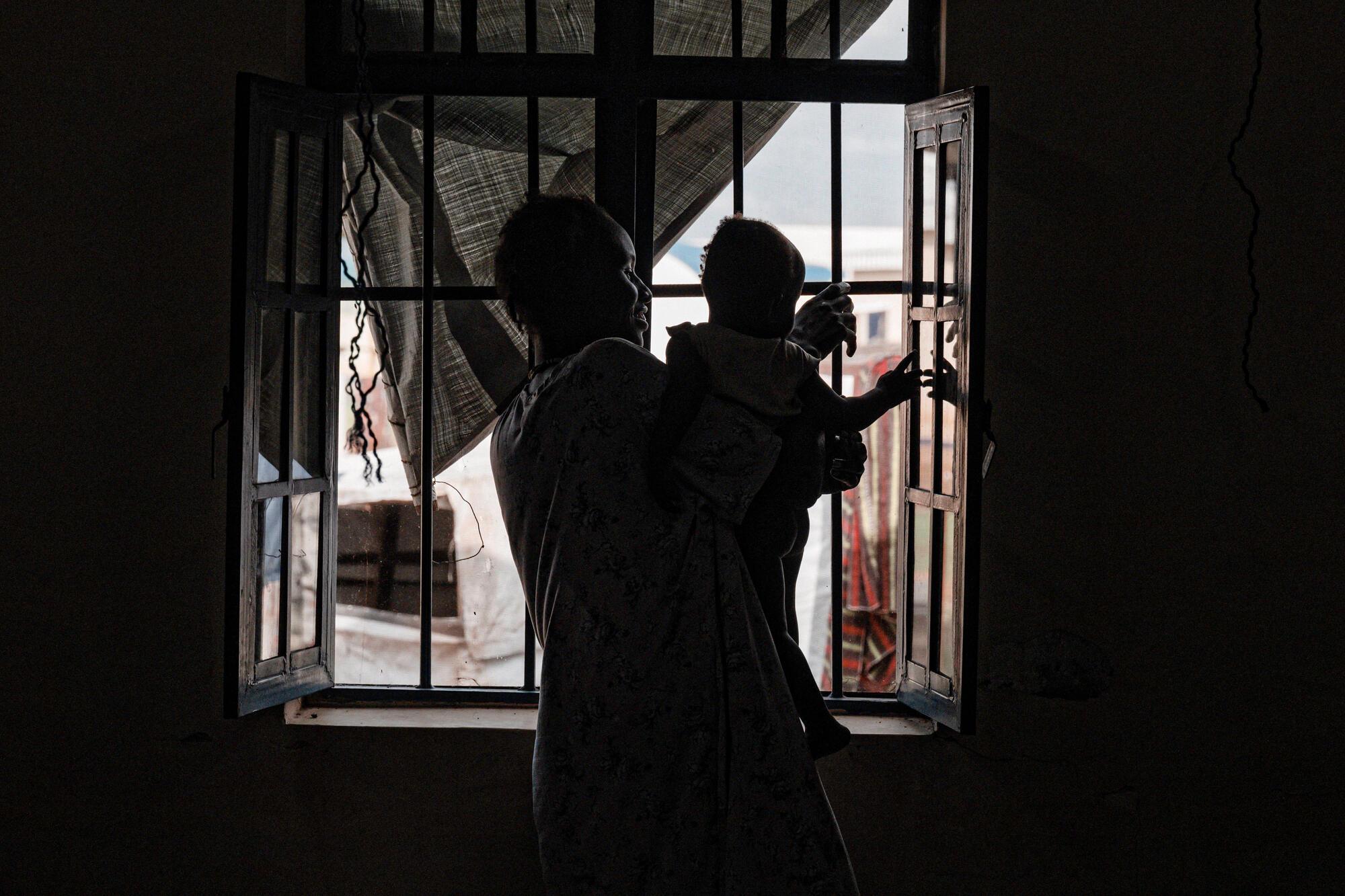 Jouer avec les réflexions. Nyaluh Majith avec son fils Anok Deng, hôpital Ameth Bek, Abyei. © Sean Sutton/Panos Pictures