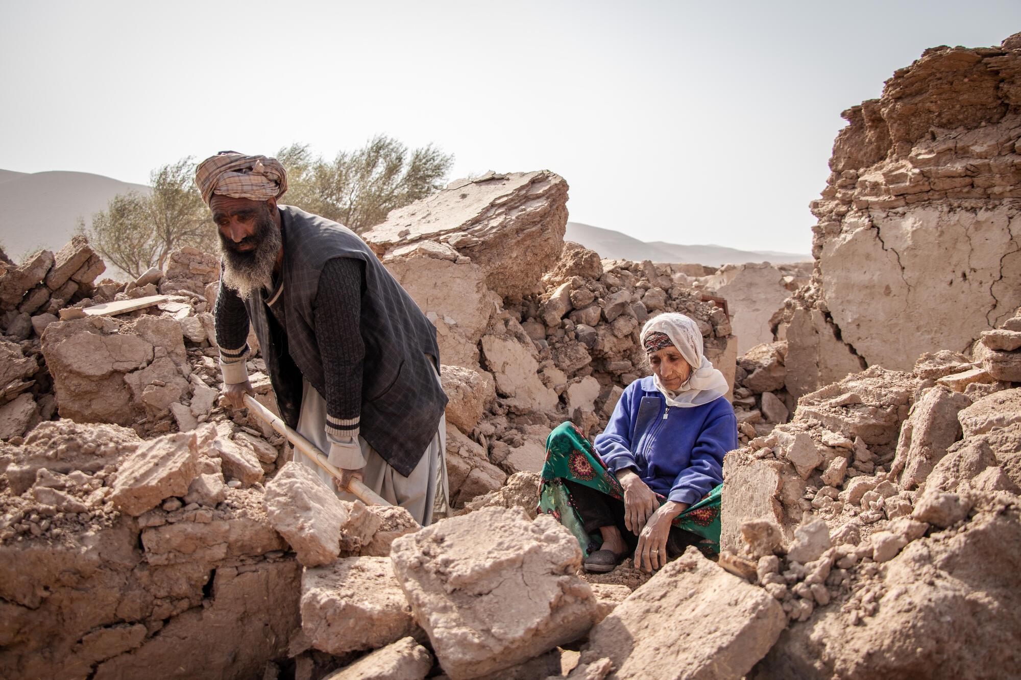 Tremblements de terre en Afghanistan. Abdul Salaam creuse dans les décombres de ce qui était sa maison à l'aide d'une pelle. Sa mère, assise sur le côté, le regarde tranquillement. © Paul Odongo/MSF