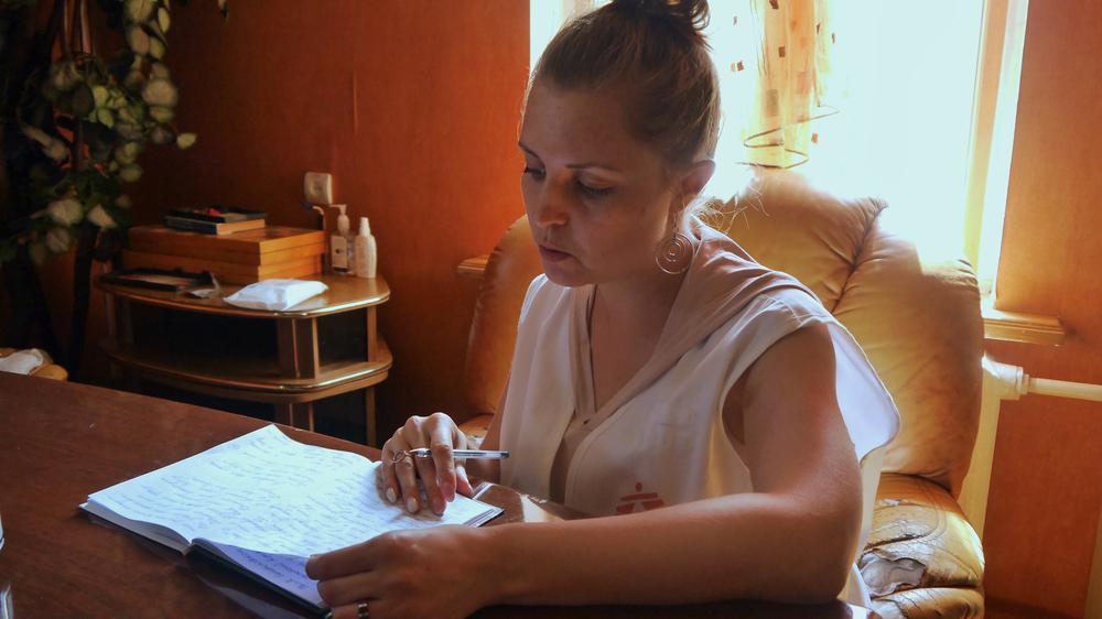 Yulia Timchenko, superviseur de la promotion de la santé chez MSF, revoit les notes prises lors des réunions avec les patients résidant dans le centre d'hébergement de Zernove qui ont été exposés par la guerre. Juillet, 2023 ©MSF/Alina Eleuterova