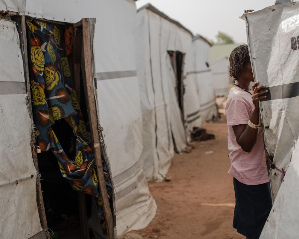 Seember parle à son voisin devant sa tente.© Kasia Strek/MSF
