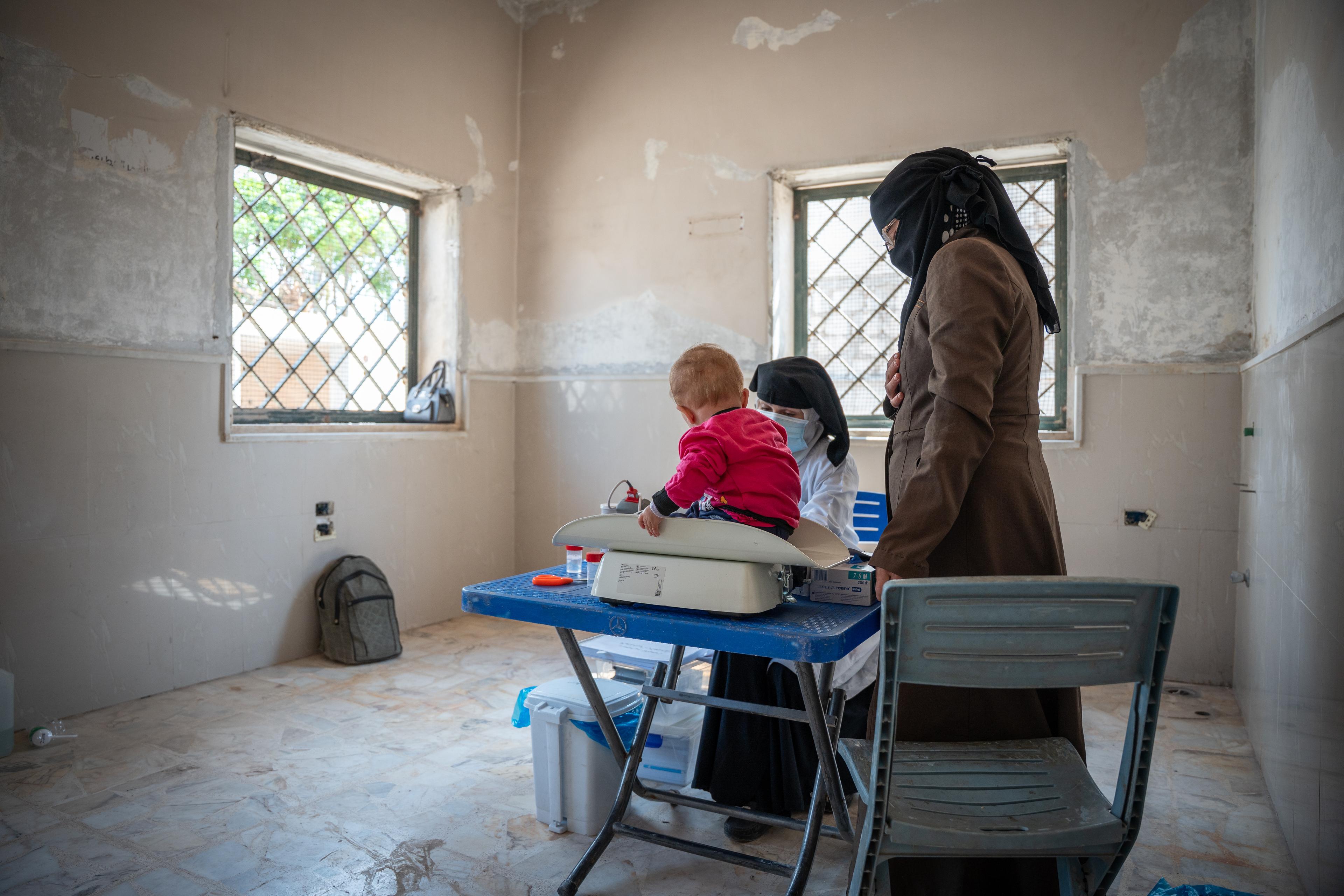 Dans la salle de triage de la clinique mobile de MSF, une infirmière mesure les signes vitaux des enfants avant leur entrée dans la salle de consultation du médecin.
