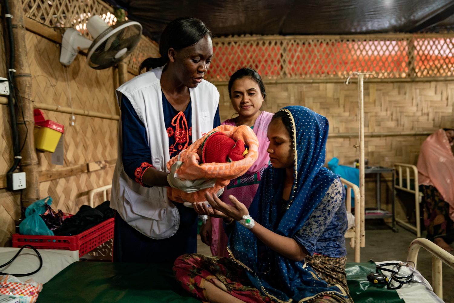  Une maman Rohingya et son bébé avec  la sage-femme qui dirige les services de maternité dans les centres de soins généraux de MSF à Jamtoli et Hakimpara de Cox’s Bazar. Bangladesh. Juillet 2019.  