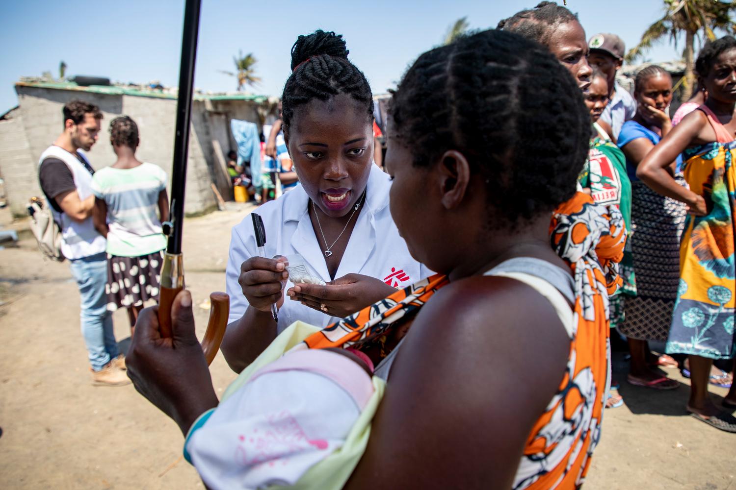 A nurse gives medication to a woman with her child at one of MSF’s mobile clinics in Beira, an area hard hit by Cyclone Idai. Mozambique, March 2019. 