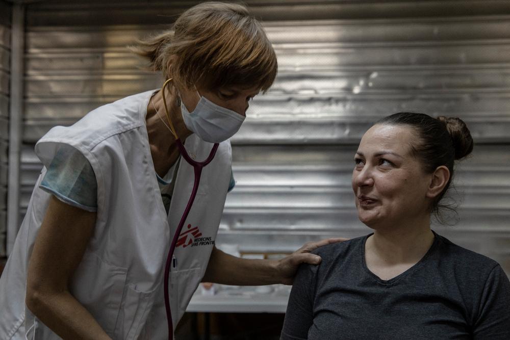 Alina, 33 ans, sourit en parlant à Kelly, un médecin MSF qui reçoit des patients dans une clinique mobile dans le métro de Kharkiv, en Ukraine, le 11 avril 2022. 