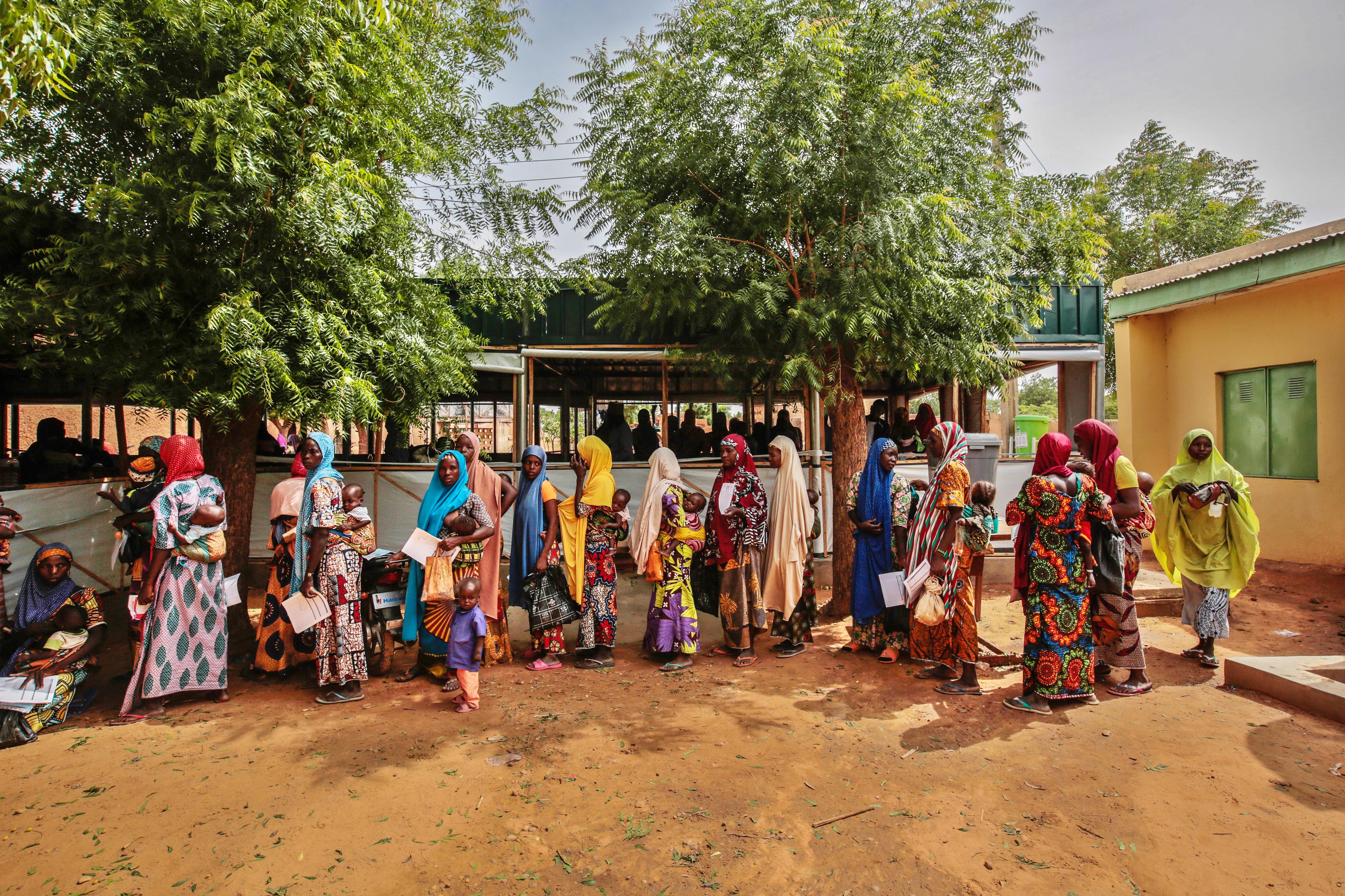 Mothers wait with their children at MSF’s ambulatory therapeutic feeding centre in Riko village. Katsina State, Nigeria, June 2022. 