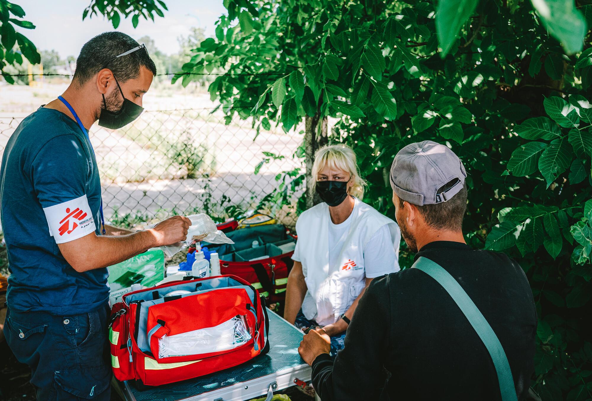 Un médiateur culturel MSF et une infirmière expliquent à un patient comment utiliser un kit médical pour les plaies lors d&#039;une consultation à la clinique mobile MSF dans la zone frontalière de Horgos 2 en Serbie. 