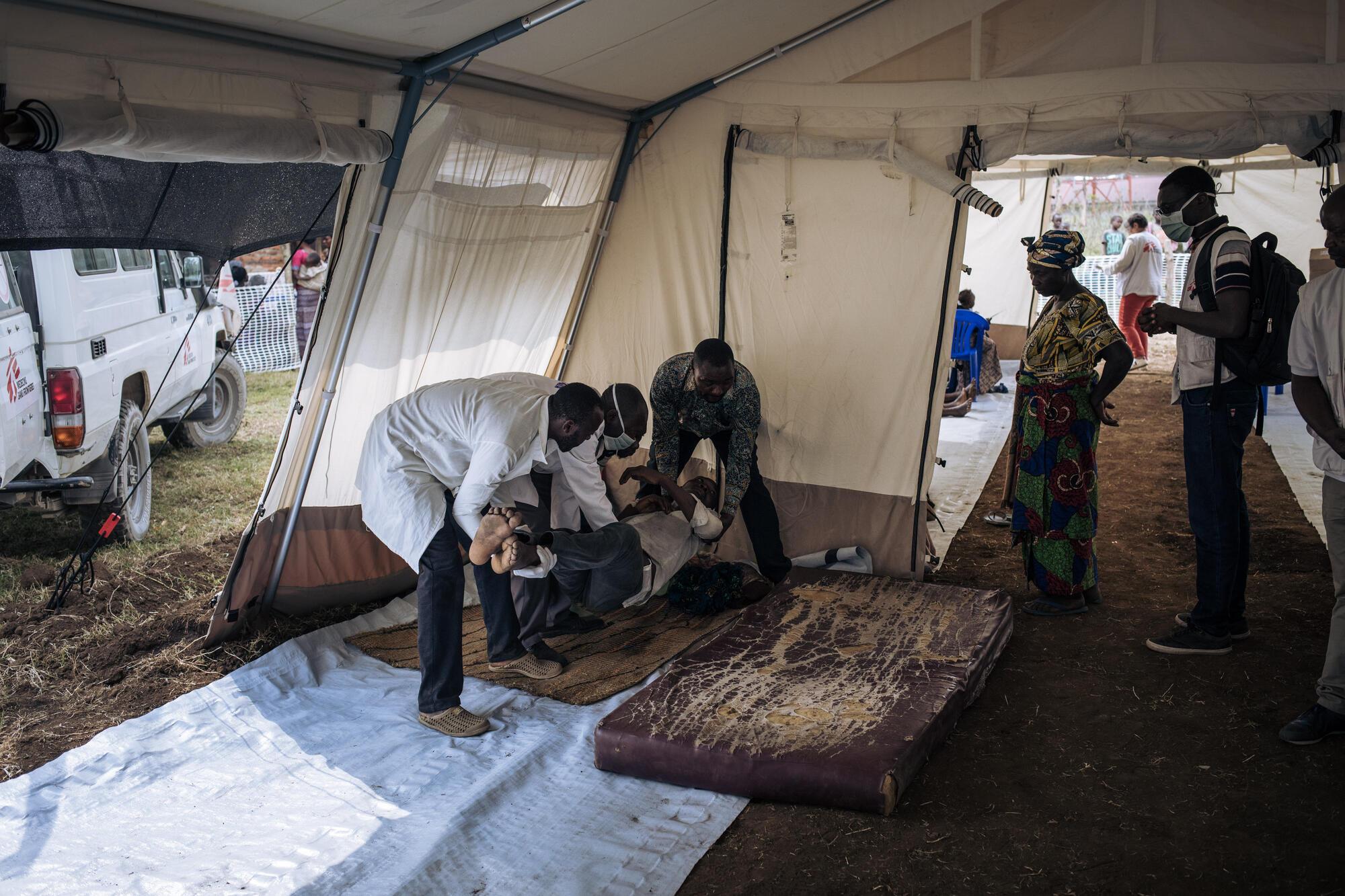 Des membres de MSF et du ministère congolais de la Santé évacuent un homme atteint de paludisme grave de la clinique mobile MSF de Rumangabo vers une clinique voisine. 