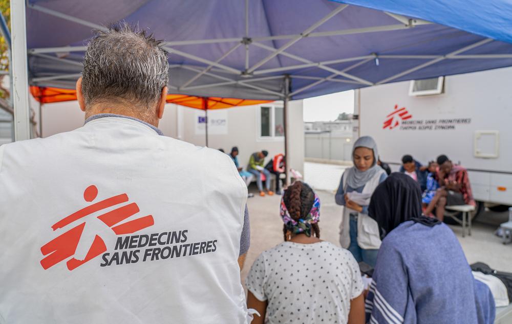 Plan moyen d&#039;un travailleur de MSF dans la zone d&#039;attente à l&#039;extérieur de la clinique mobile dans le centre d&#039;accès à contrôle fermé à Zervou, Samos. 