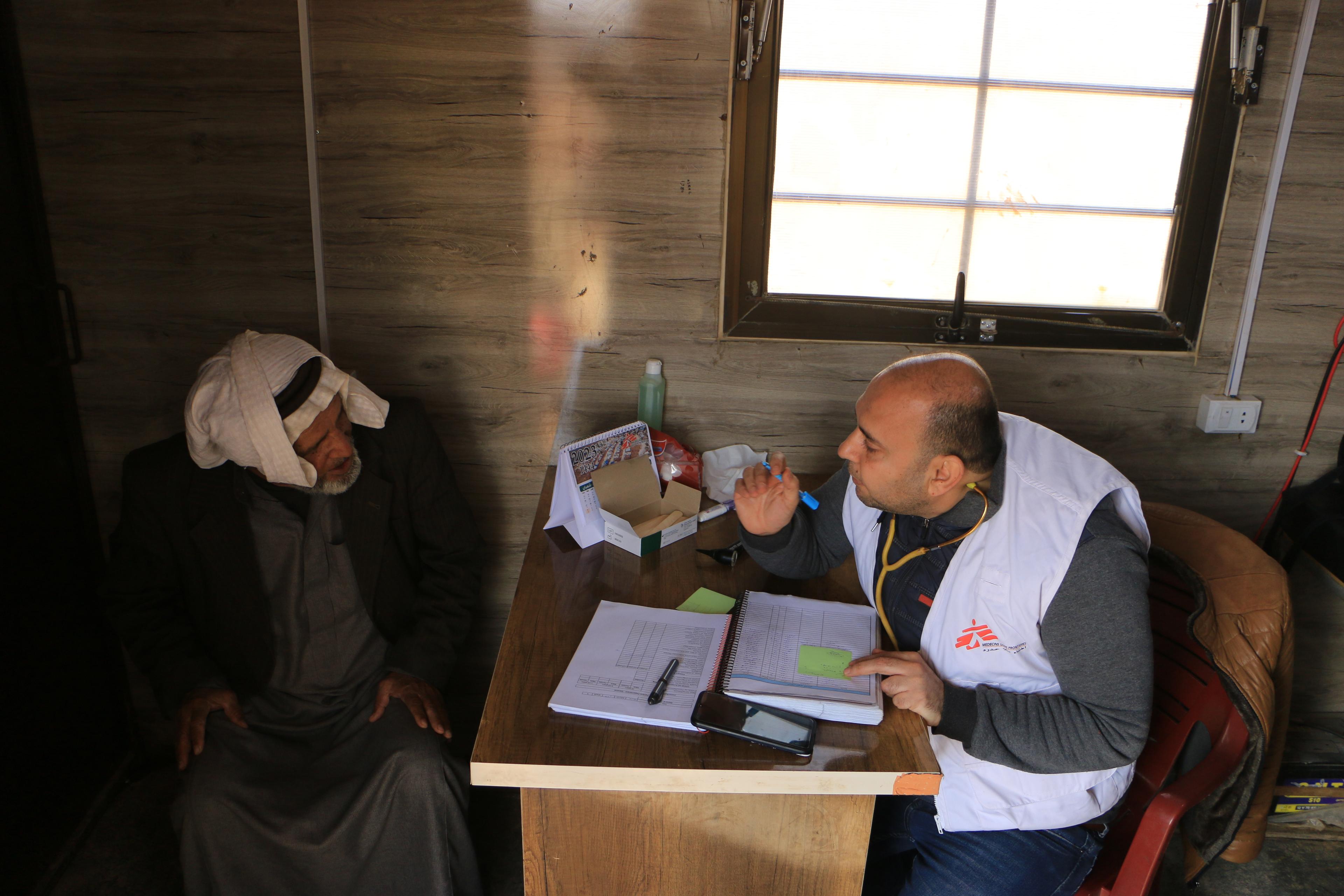 An MSF doctor in consultation with a patient in Al-Fuqara camp in Idlib governorate.  
