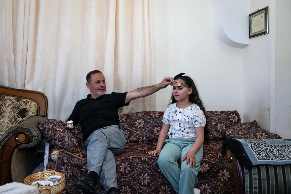Yasser Abu Markhiyeh montre les yeux de sa fille suite à une attaque de colons alors qu&#039;elle était bébé, dans sa maison à Hébron le 2 mai 2023. 