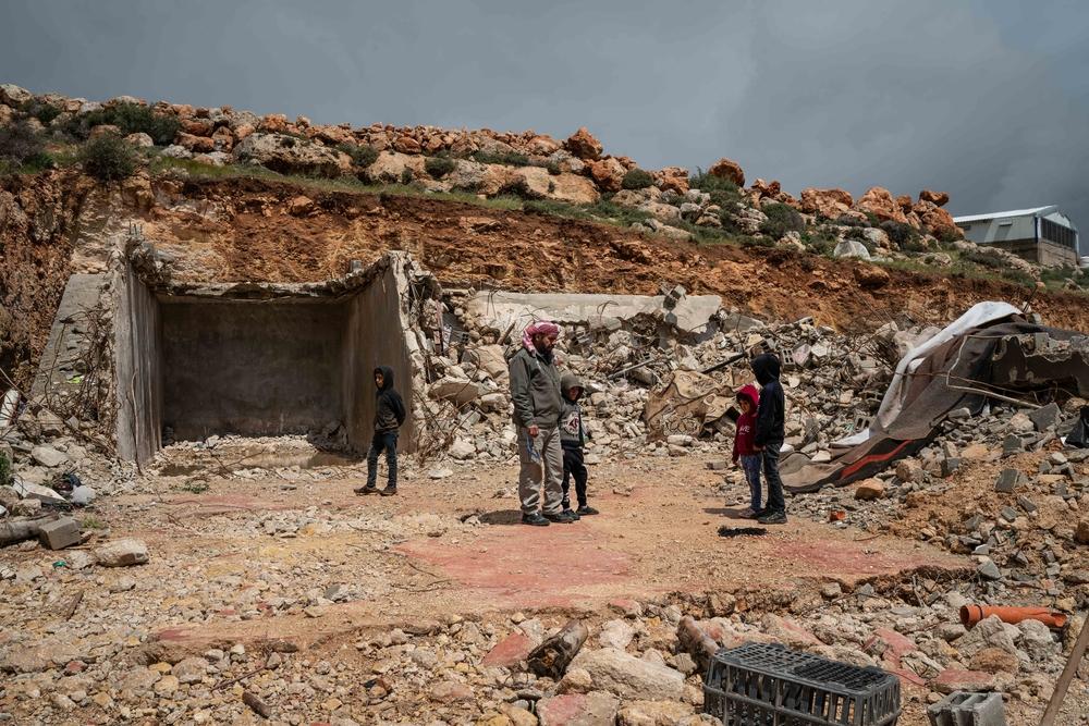 Mustafa Mlikat et ses enfants aux côtés des décombres de sa maison qui a été démolie par les forces israéliennes, à Douma le 13 avril 2023. 