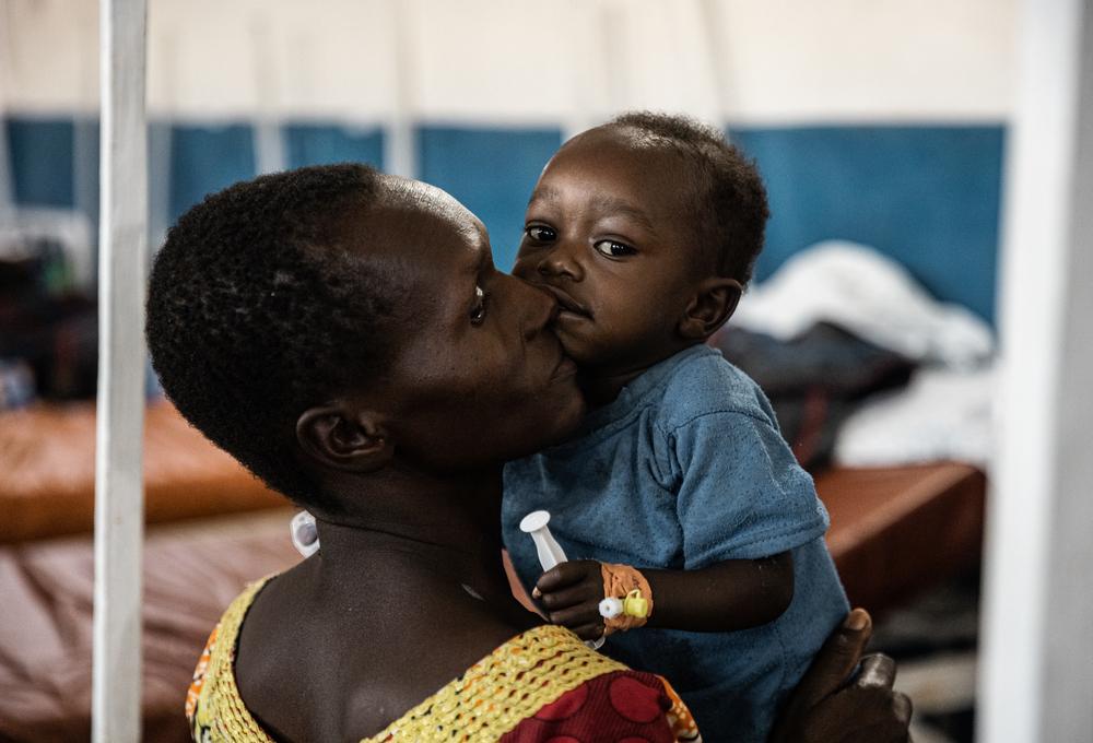 Portrait de Joecie jouant avec son fils Saloomon, âgé de 17 mois, assis sur le lit de l&#039;unité pédiatrique de l&#039;hôpital de référence de Drodro, Ituri, RDC. 