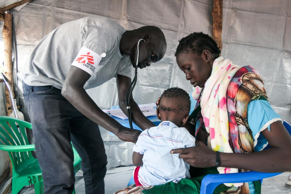 Chuol Hoth, agent clinique MSF, examine un enfant à la clinique mobile MSF dans le centre de transit de Bulukat, État du Haut-Nil, Soudan du Sud. Août 2023. 