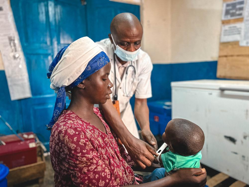 Alliance's 12-month-old son François receives a medical consultation as part of the nutrition programme at the Nyabiondo referral health centre in Masisi territory. DRC, September 2023. 