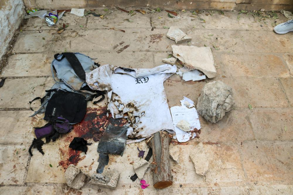 Bloody clothes and a marked page of homework are laid out over the area where an airstrike reportedly killed two children, two adults and severely injured around two dozen others in Jenin refugee camp on 25 October 2023 