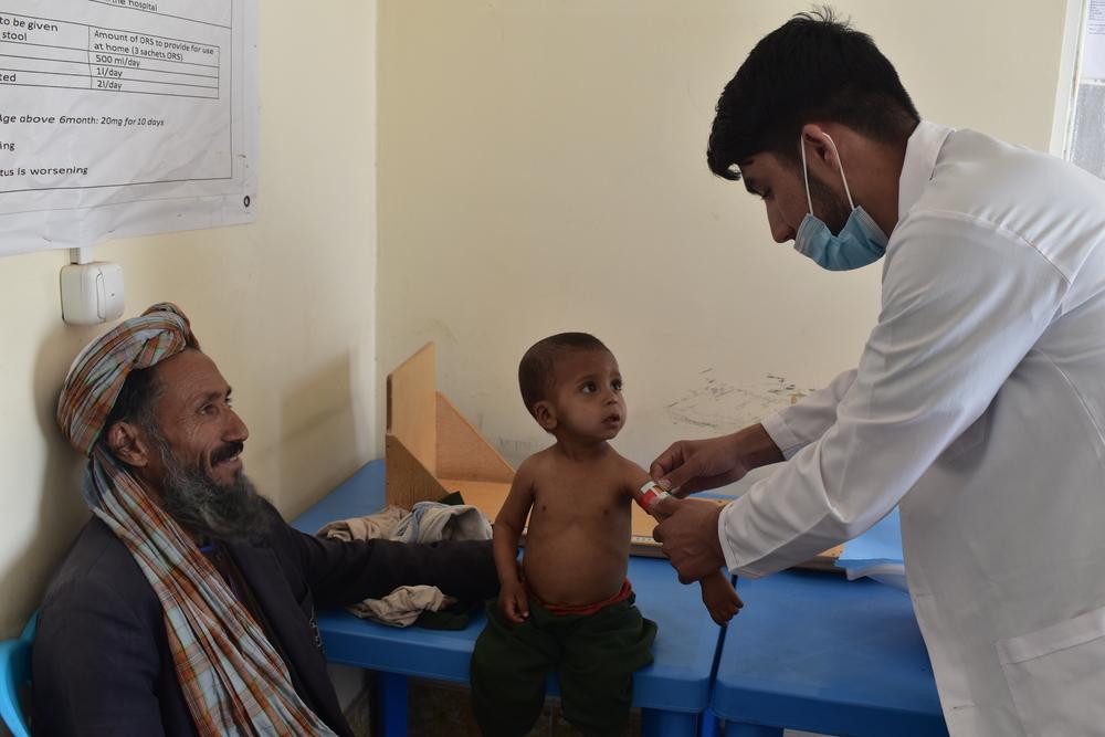 Une infirmier nutritionniste de MSF évalue la circonférence du milieu du bras d&#039;un enfant dans la clinique pour personnes déplacées de MSF au Kahdistan, à Shaydayee, Herat. Afghanistan, décembre 2020. 