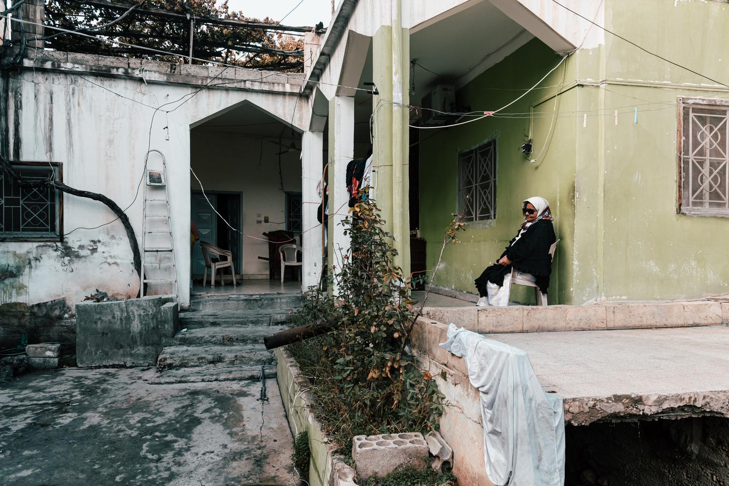 Fatima est assise devant la maison de ses beaux-parents, où elle vit avec son mari et sa fille unique, à Hermel, dans le nord de la vallée de la Bekaa. Liban, décembre 2020. 