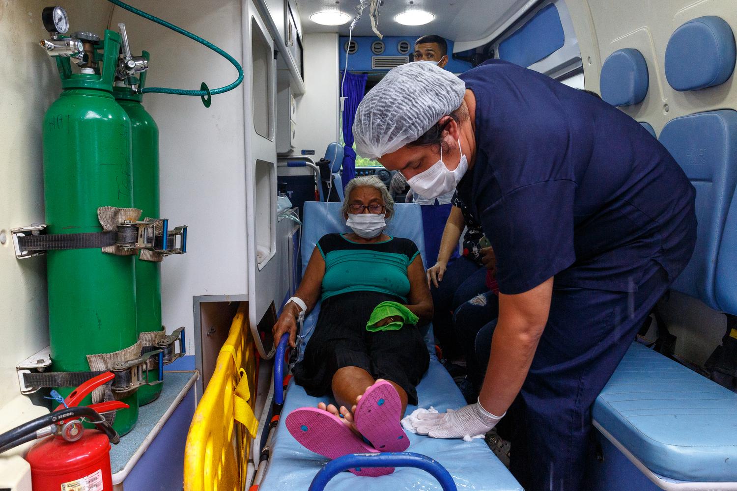 Une patiente qui était dans le service Covid-19 est transportée dans une ambulance qui la conduira à l'aéroport de Tefé. Les médecins ont décidé de la tranférer vers la capitale de l'État, Manaus, où il existe davantage de ressources pour son traitement contre le Covid-19. État d'Amazonas, Brésil, décembre 2020. 