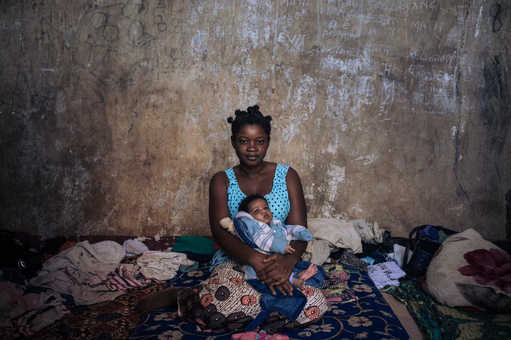 Christelle tient dans ses bras sa petite fille Alvina à Ndu, dans l&#039;école où elle vit depuis l&#039;attaque de Bangassou en République Centrafricaine. 