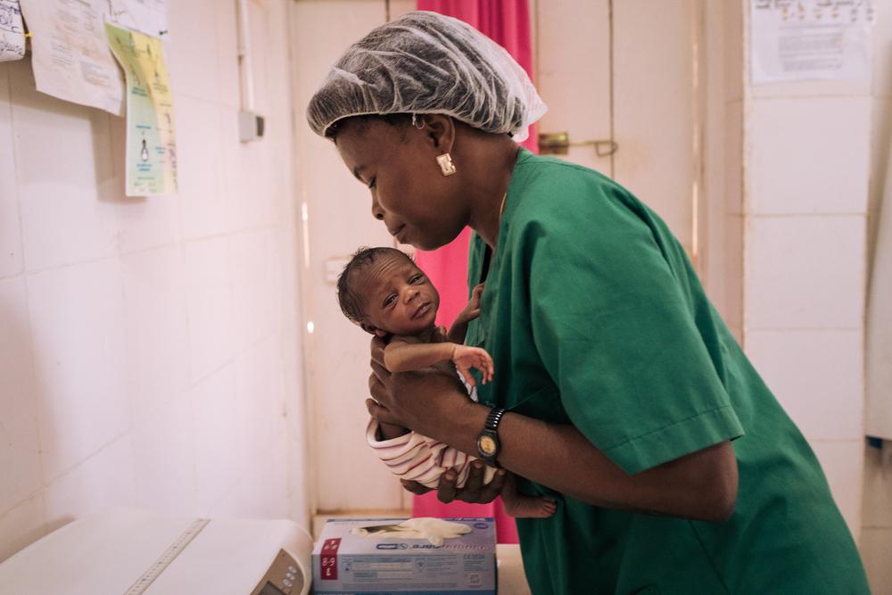 Laure, sage-femme au centre de santé de Ndu, en République démocratique du Congo, examine l&#039;un des jumeaux nouvellement nés d&#039;Ester, le 27 janvier 2021. 