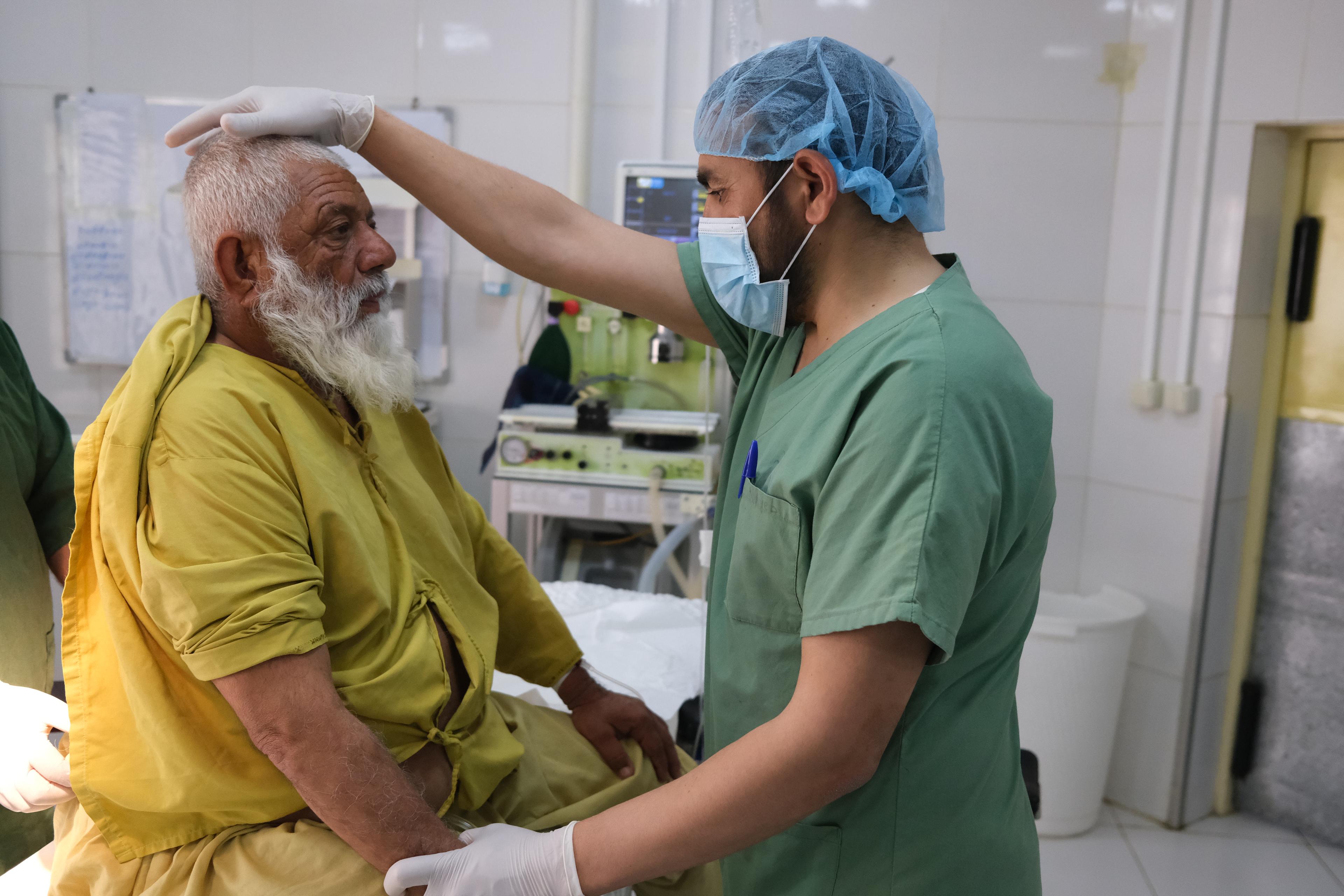 Wais Mohammad, anesthésiste MSF, effectue un contrôle sur Esa, 63 ans, avant une intervention chirurgicale pour enlever un calcul rénal à l'hôpital Boost à Lashkar Gah, province de Helmand, Afghanistan. Mai 2021 
