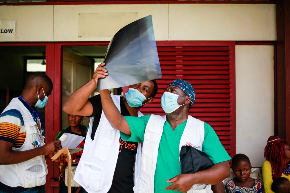 Le Dr Jules (à droite) et le Dr Stephen tiennent la radiographie d'un patient à contre-jour à l'hôpital du district de Mamfe, dans le sud-ouest du Cameroun. Juin, 2021 