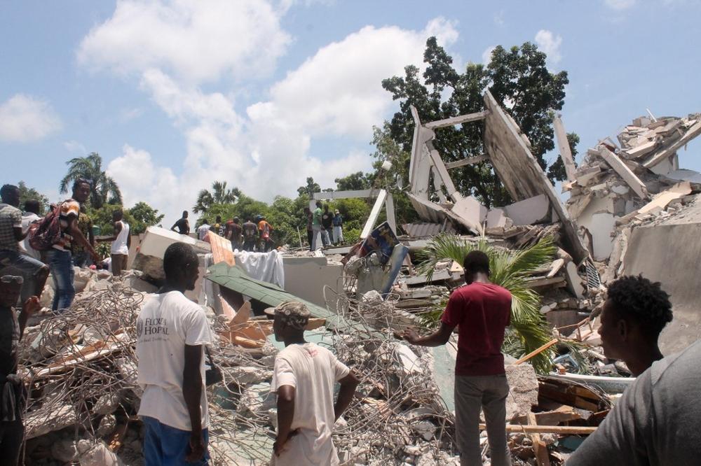 Des personnes fouillent dans les décombres de ce qui était l'hôtel Manguier après le tremblement de terre du 14 août 2021 aux Cayes, dans le sud-ouest d'Haïti. 