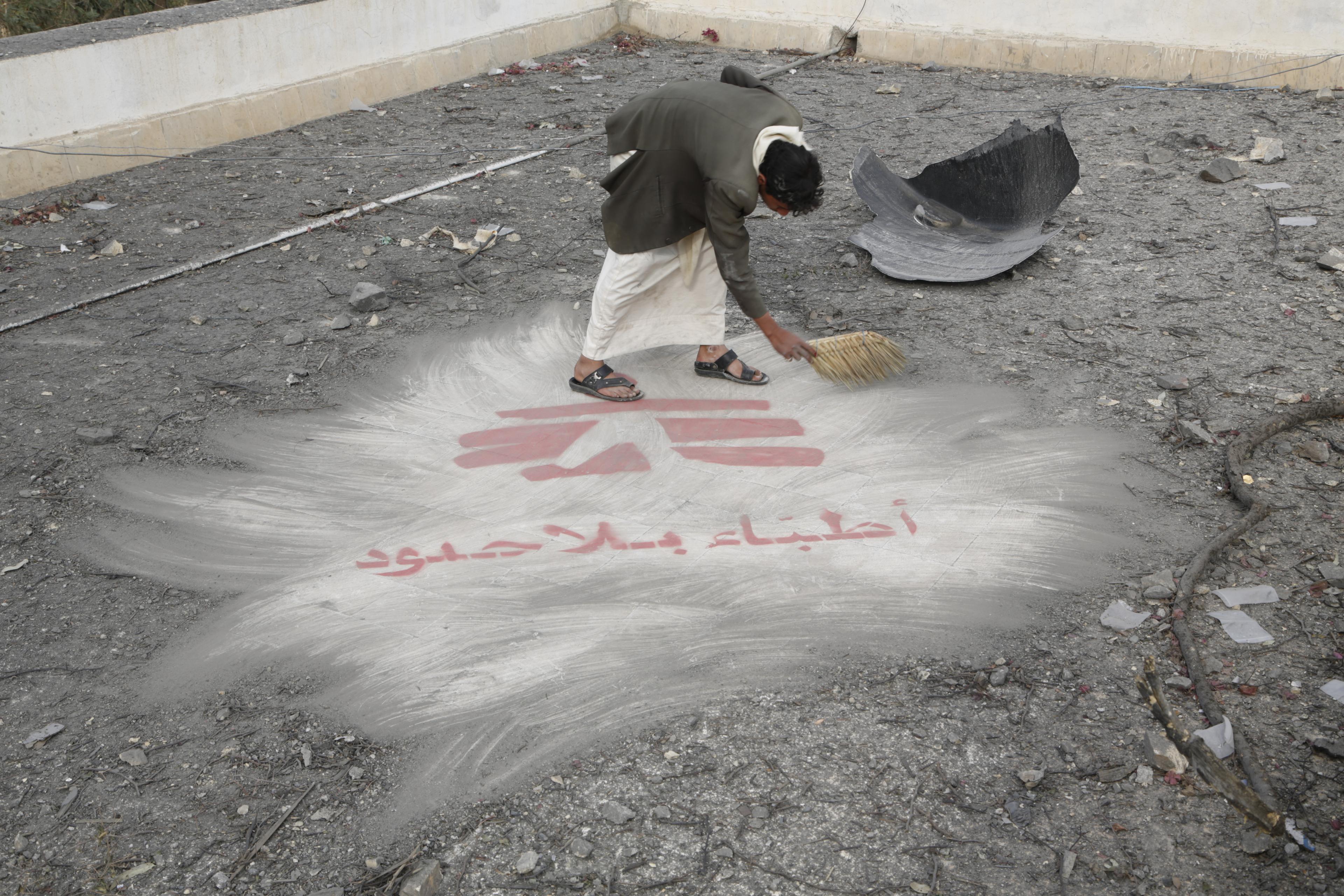 Un homme dégage des débris révélant le logo de MSF peint sur le toit de l'hôpital de MSF à Haydan, au Yémen, après une frappe aérienne sur l'établissement. Octobre 2015. Yémen. 