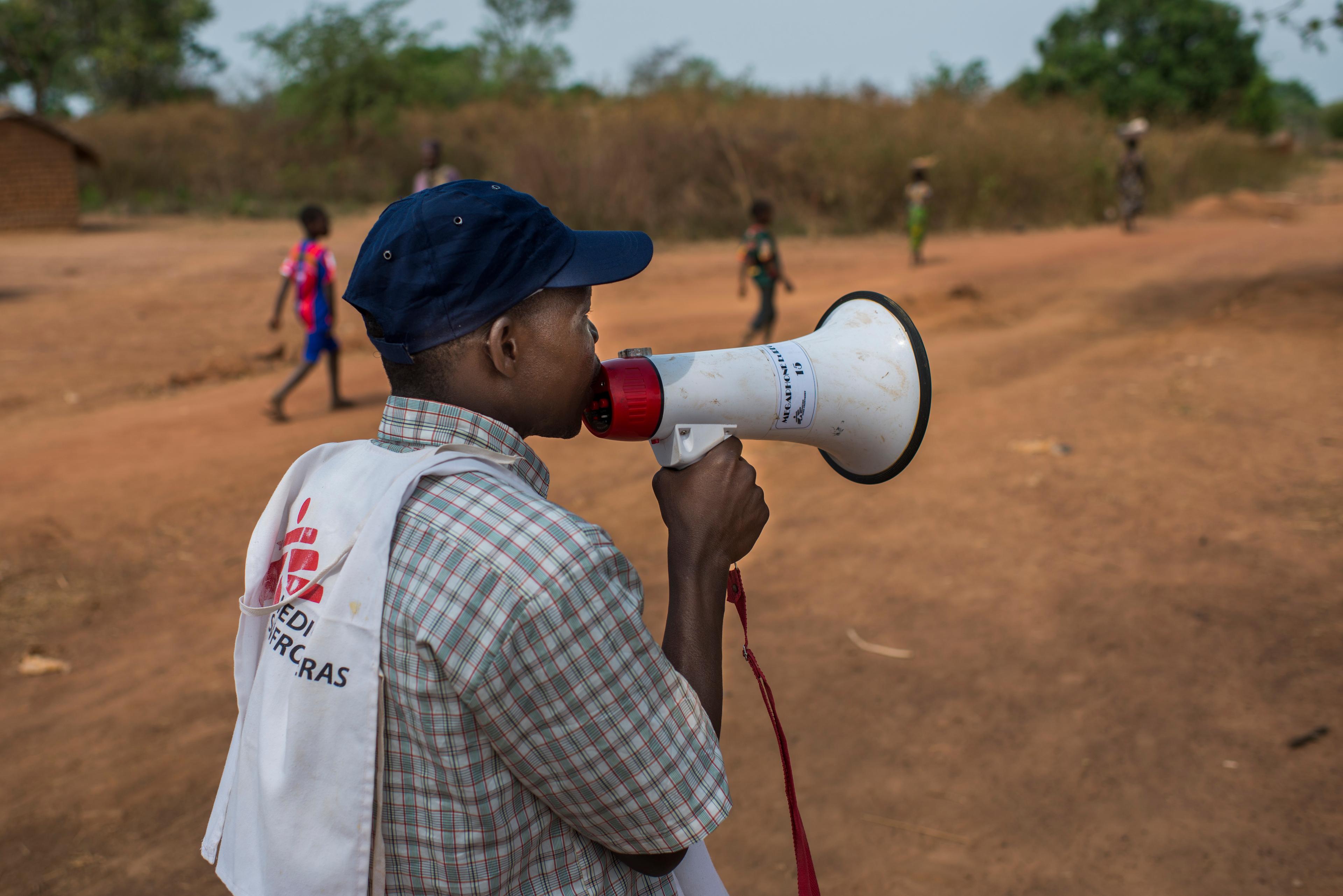Un membre du personnel de MSF sensibilise la population lors d'une campagne de vaccination à Maloum : informer sur les bénéfices de la vaccination est crucial. Mars 2017. République centrafricaine. 