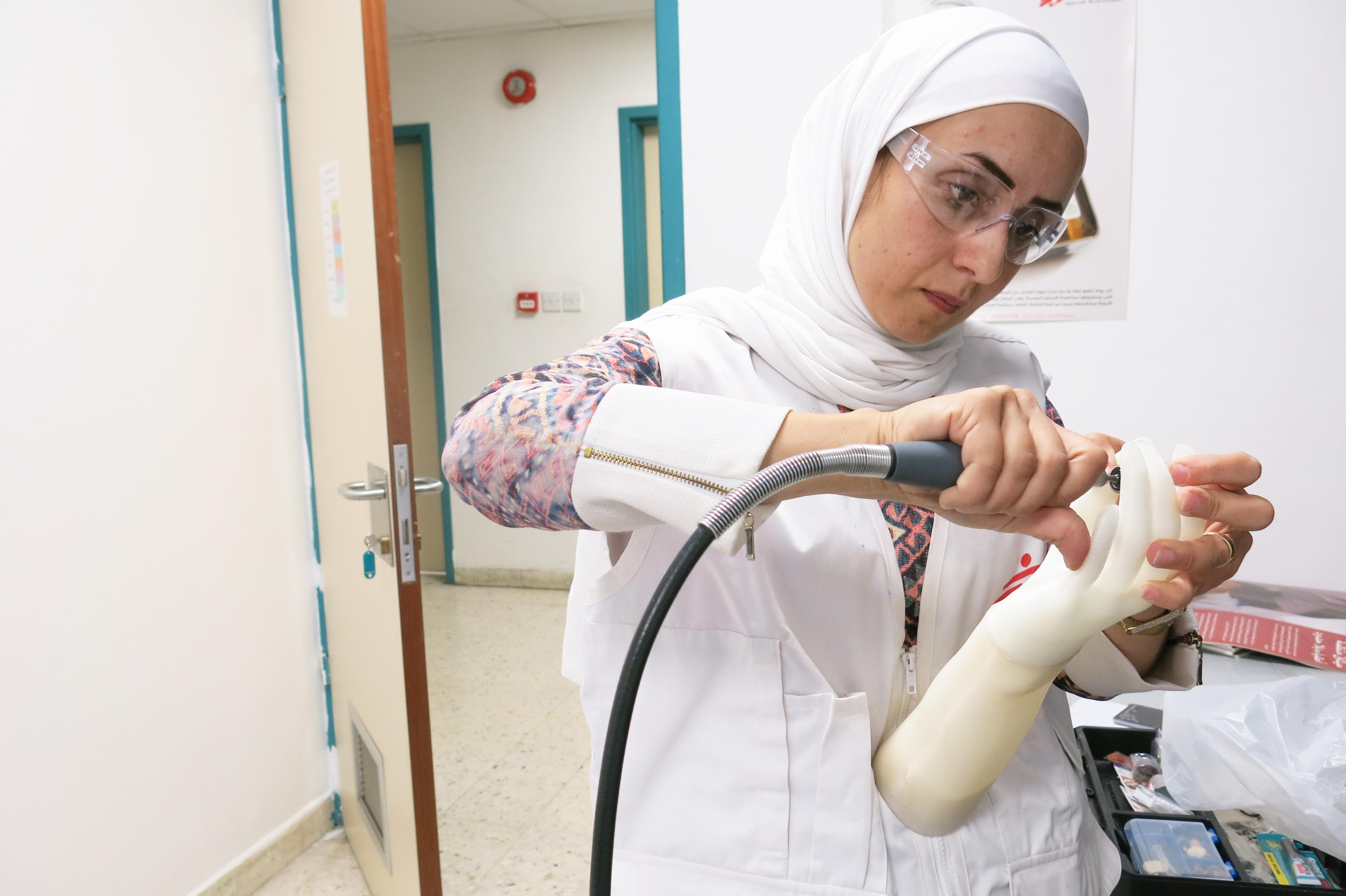 Superviseur du projet 3D à Amman, Jordanie, modifie une prothèse de membre supérieur à l'aide d'une perceuse. Jordanie, 2018. 