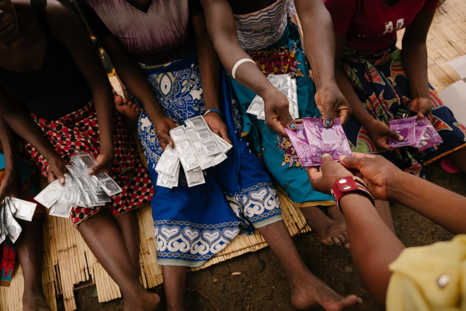 Les travailleurs du sexe reçoivent des préservatifs et du lubrifiant lors d&#039;une séance de promotion de la santé menée discrètement dans un lieu sensible de Nsanje. Malawi, octobre 2019  