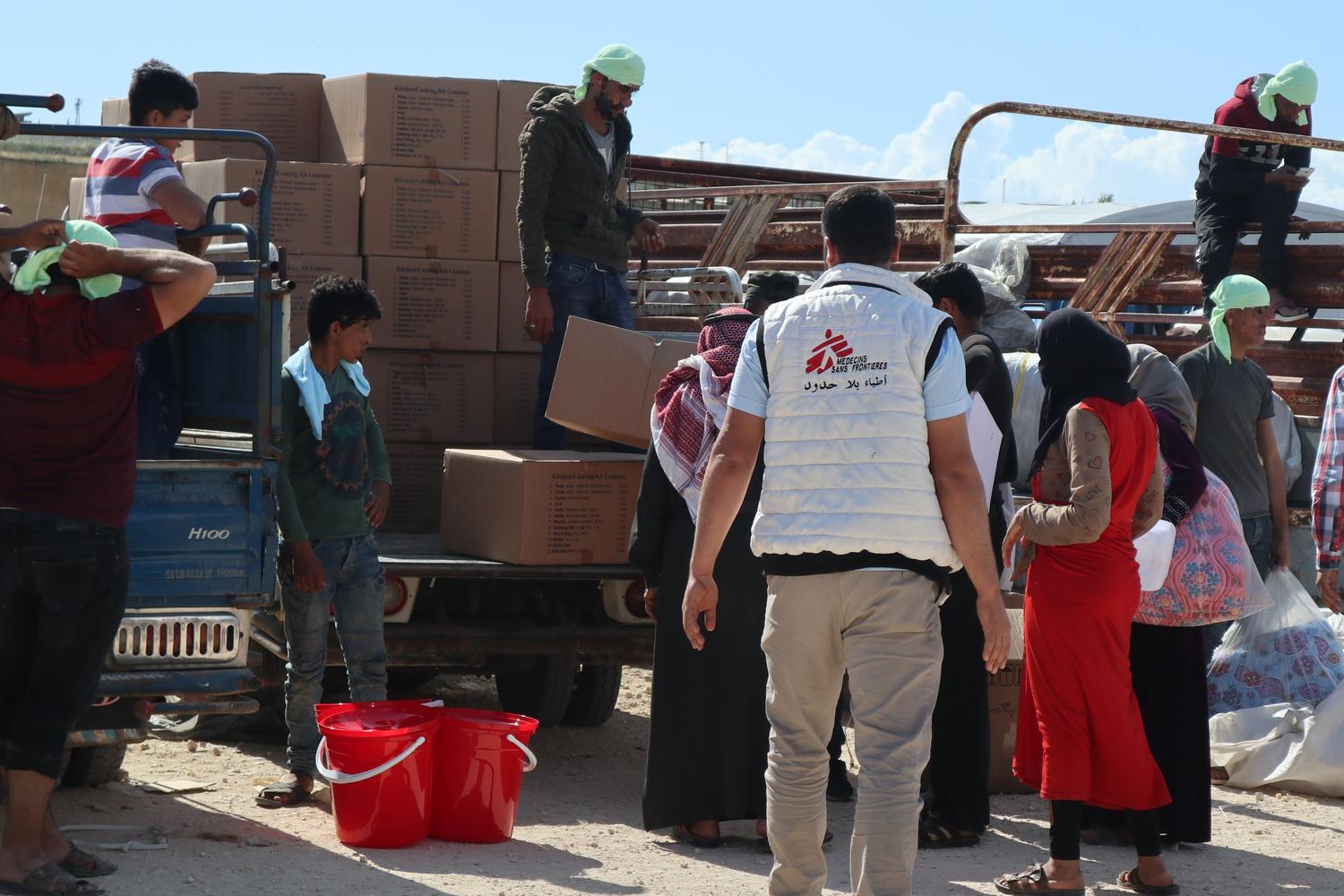 MSF distributes relief items and provides water to newly displaced people in a camp in northwest Syria, May 2019. 