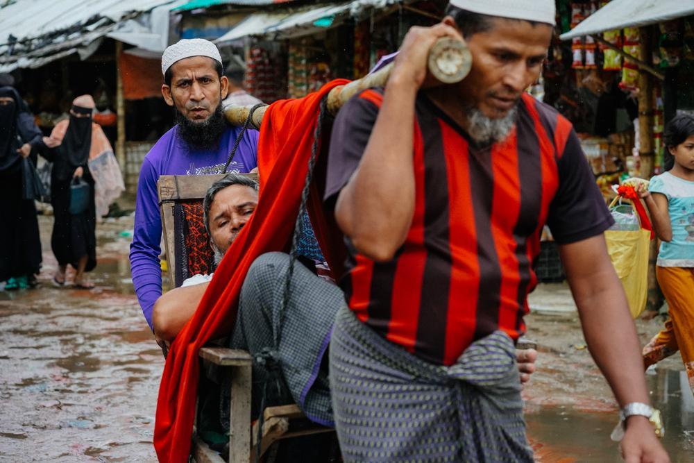 Un homme est transporté vers un établissement de santé à l'aide d'un brancard de fortune en bambou