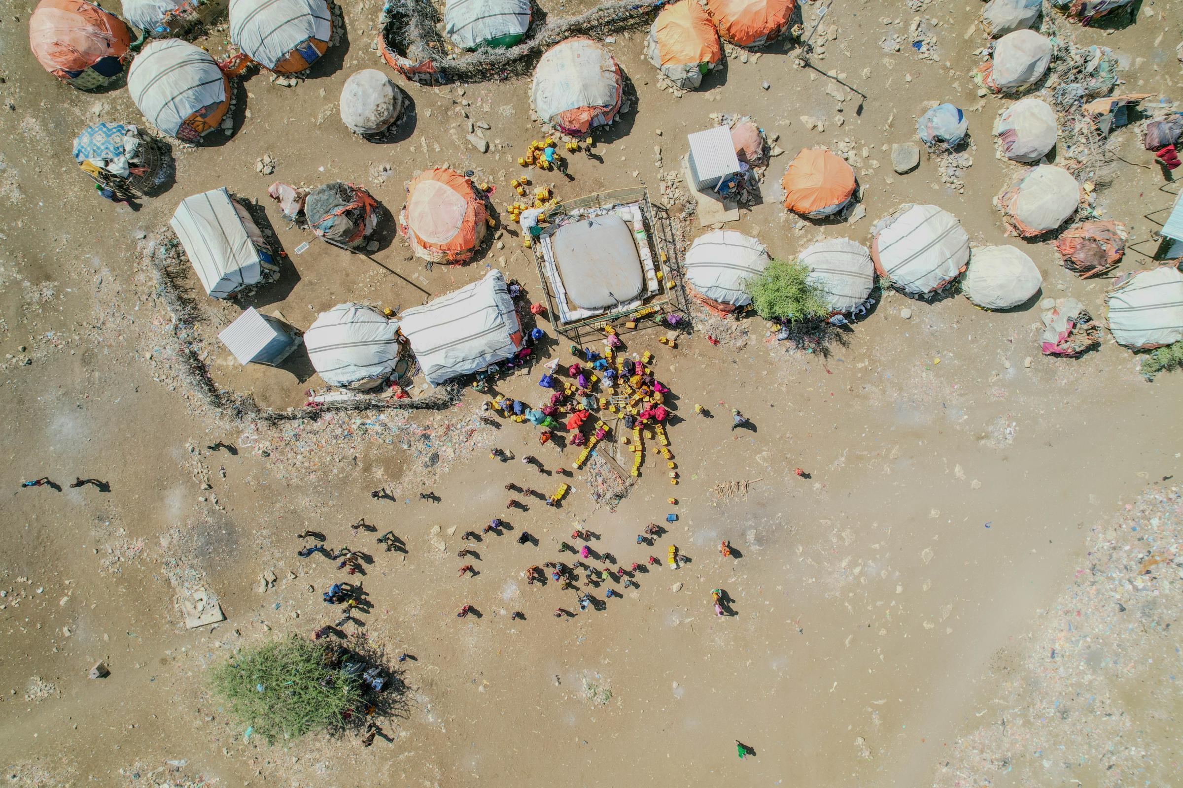 Une vue aérienne en plongée du camp de déplacés de Nimole, à Baidoa (Somalie), révèle des abris de fortune regroupés dans un paysage aride. Les familles déplacées endurent des conditions de vie extrêmement difficiles en attendant de l'aide.
