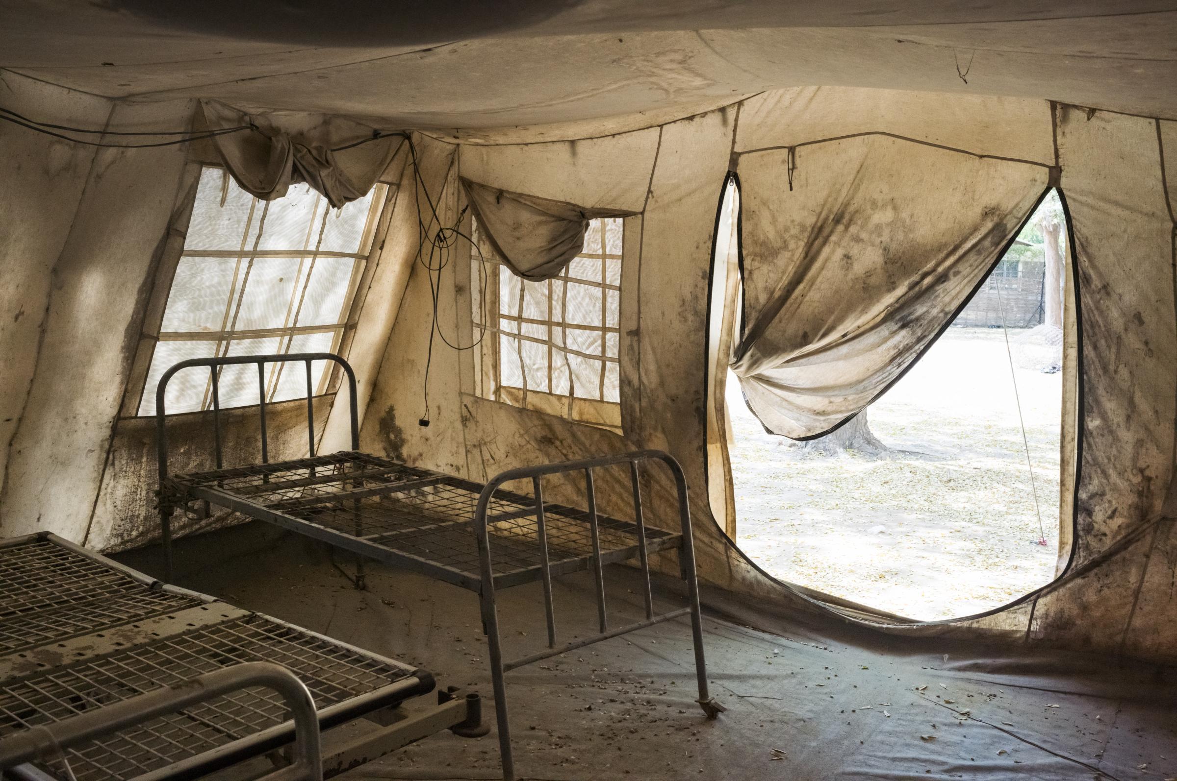 Dans l'enceinte de l'hôpital Mère Teresa, une tente en toile vide, aux sommiers rouillés, sert de salle d'appoint lorsque le nombre de patients augmente, à Turalei, dans le comté de Twic, au Soudan du Sud.