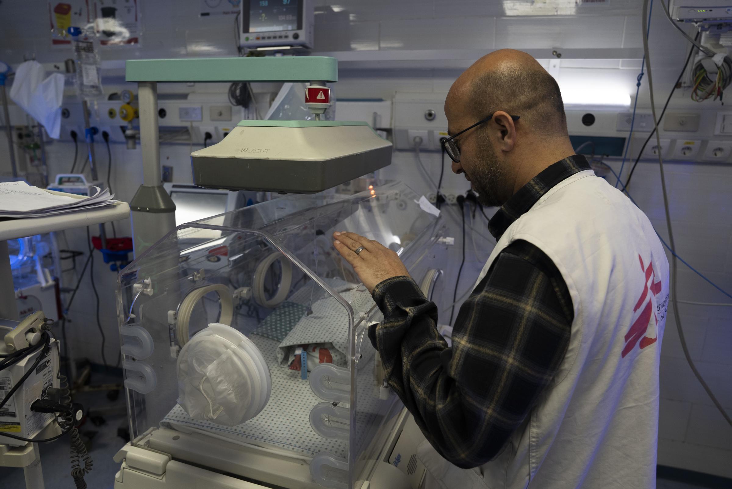 Mohammed Shehada, responsable des soins infirmiers à l'hôpital Al-Helou de la ville de Gaza, examine un nouveau-né de faible poids allongé dans une couveuse. Palestine, avril 2026. © Nour Alsaqqa/MSF