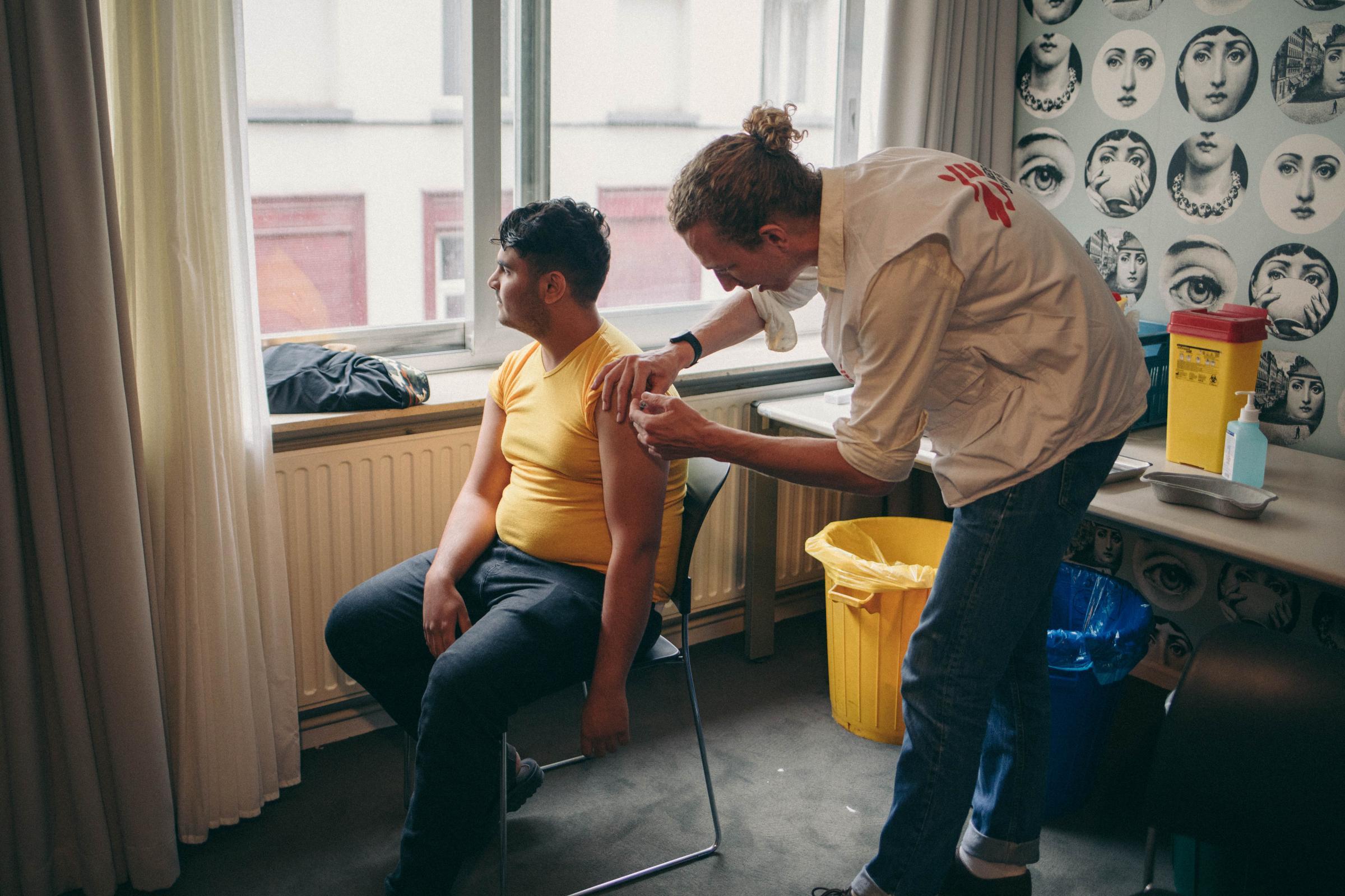 Maxime, médecin, en train d'administrer une dose à Obeid Aymann Ismael, qui vient de Palestine. Bruxelles, Belgique.