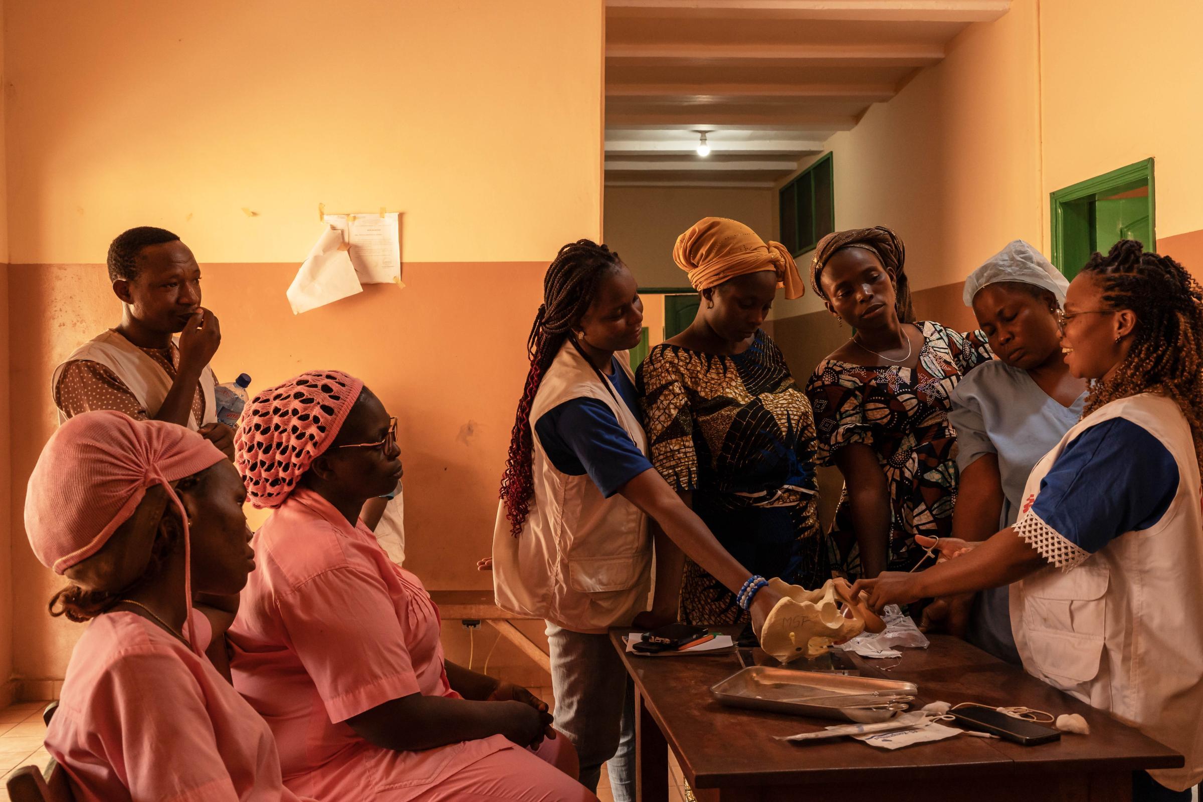 Victoire, 26 ans, sage-femme de MSF, montre comment insérer un dispositif intra-utérin (DIU) lors d'une session de formation pour les sages-femmes et les infirmières d'État au centre de santé de Toviklin, au Bénin