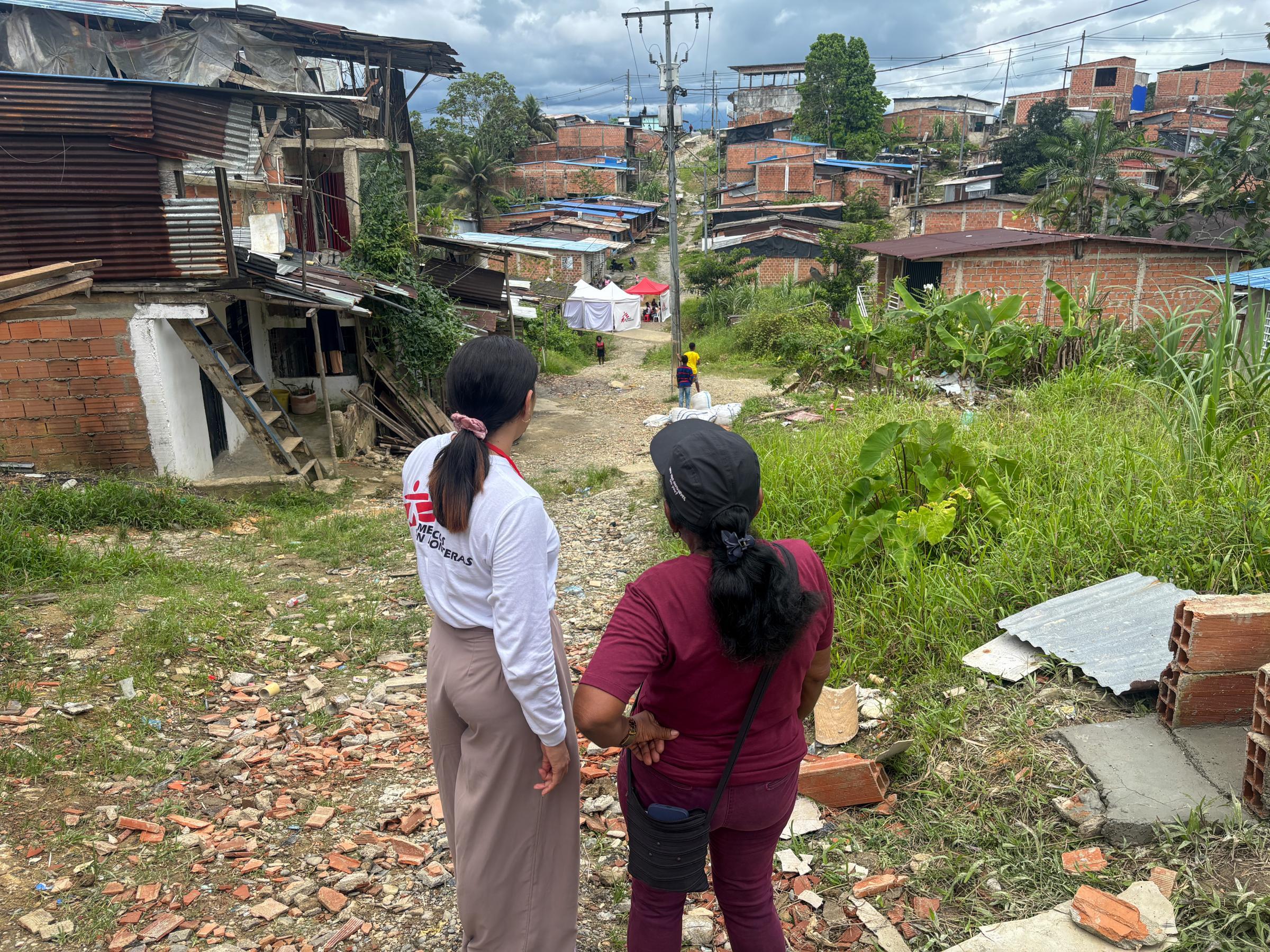 Yohanis Alvarez, technicien en eau et assainissement, visite le quartier de La Carmelita (Buenaventura) avec Teresa Bautista, une responsable communautaire.