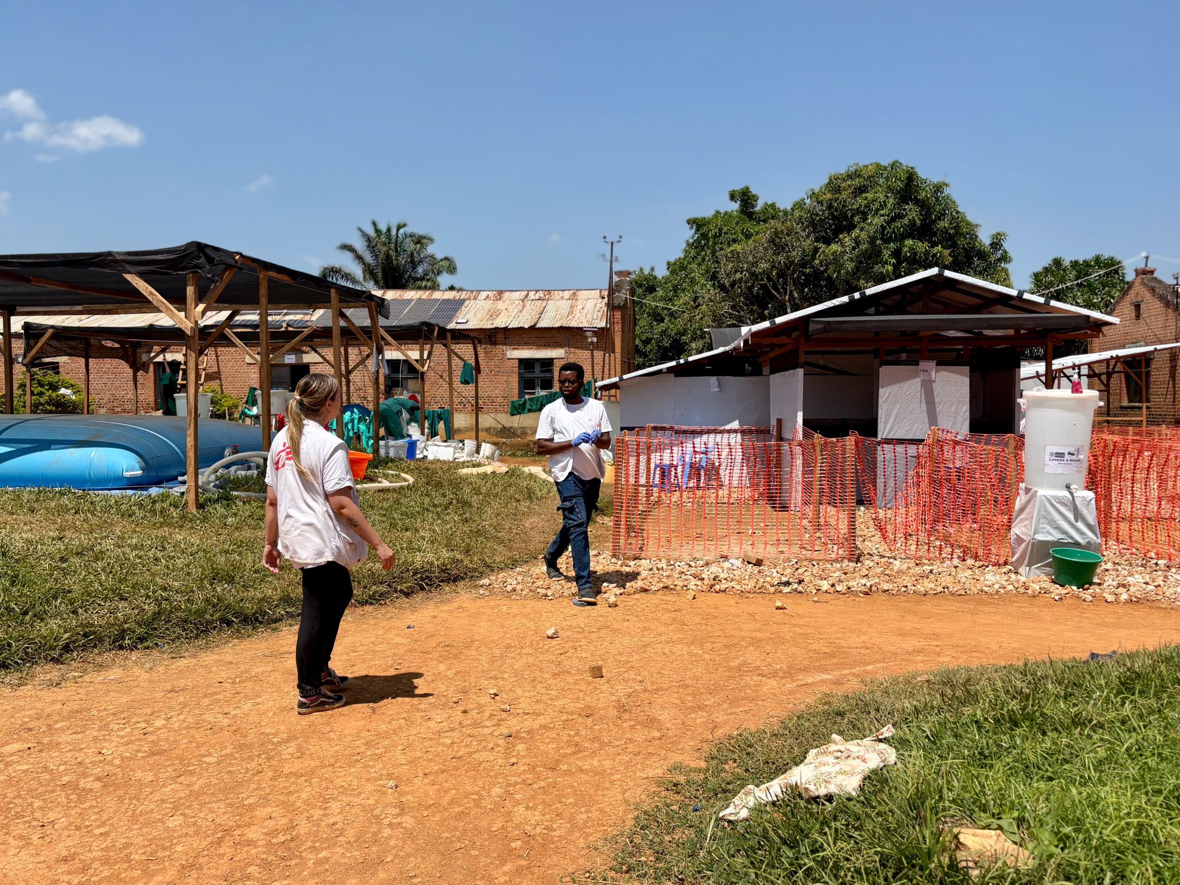 Le personnel de MSF passe devant l'entrée de la zone de triage du centre de traitement des urgences de MSF à l'hôpital général de référence de Bambu, RDC