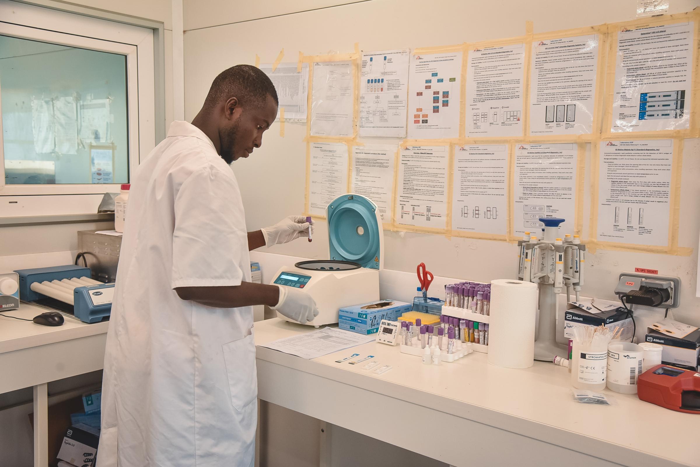 Vamba Sesay, technicien de laboratoire au ministère de la Santé, effectue un test de dépistage sérologique sur des échantillons sanguins de patients au laboratoire de l'hôpital gouvernemental de maternité et d'enfants de Hangha, dans le district de Kenema soutenu par MSF, en Sierra Leone.